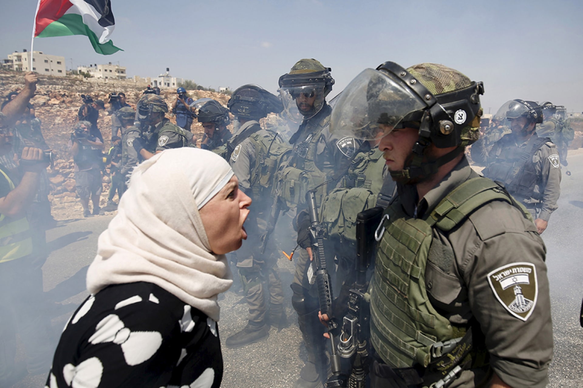 <p>A Palestinian woman argues with an Israeli border policeman in the West Bank.</p>