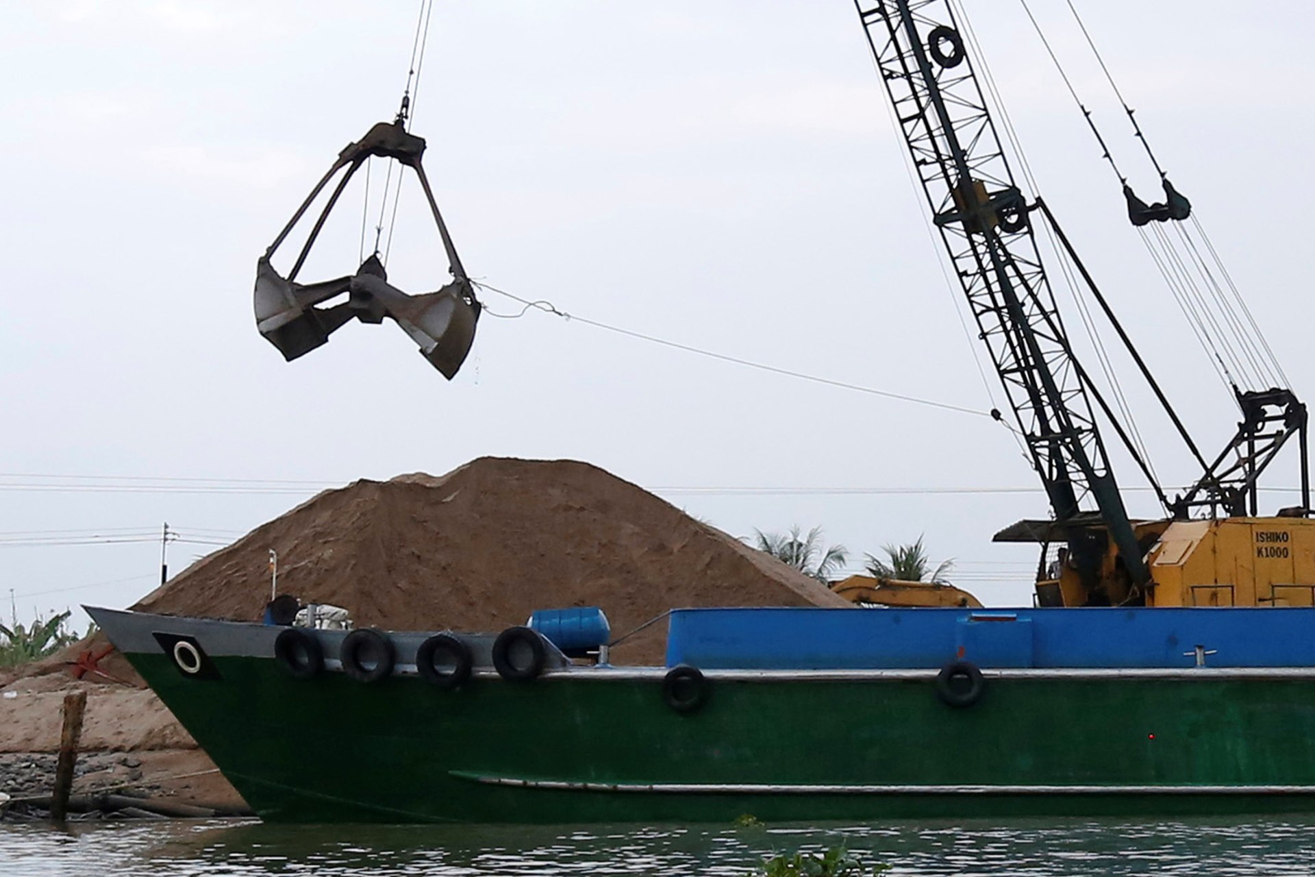 <p>A crane moves sand from a ship on Mekong river in Hau Giang province, Vietnam on December 19, 2018.</p>