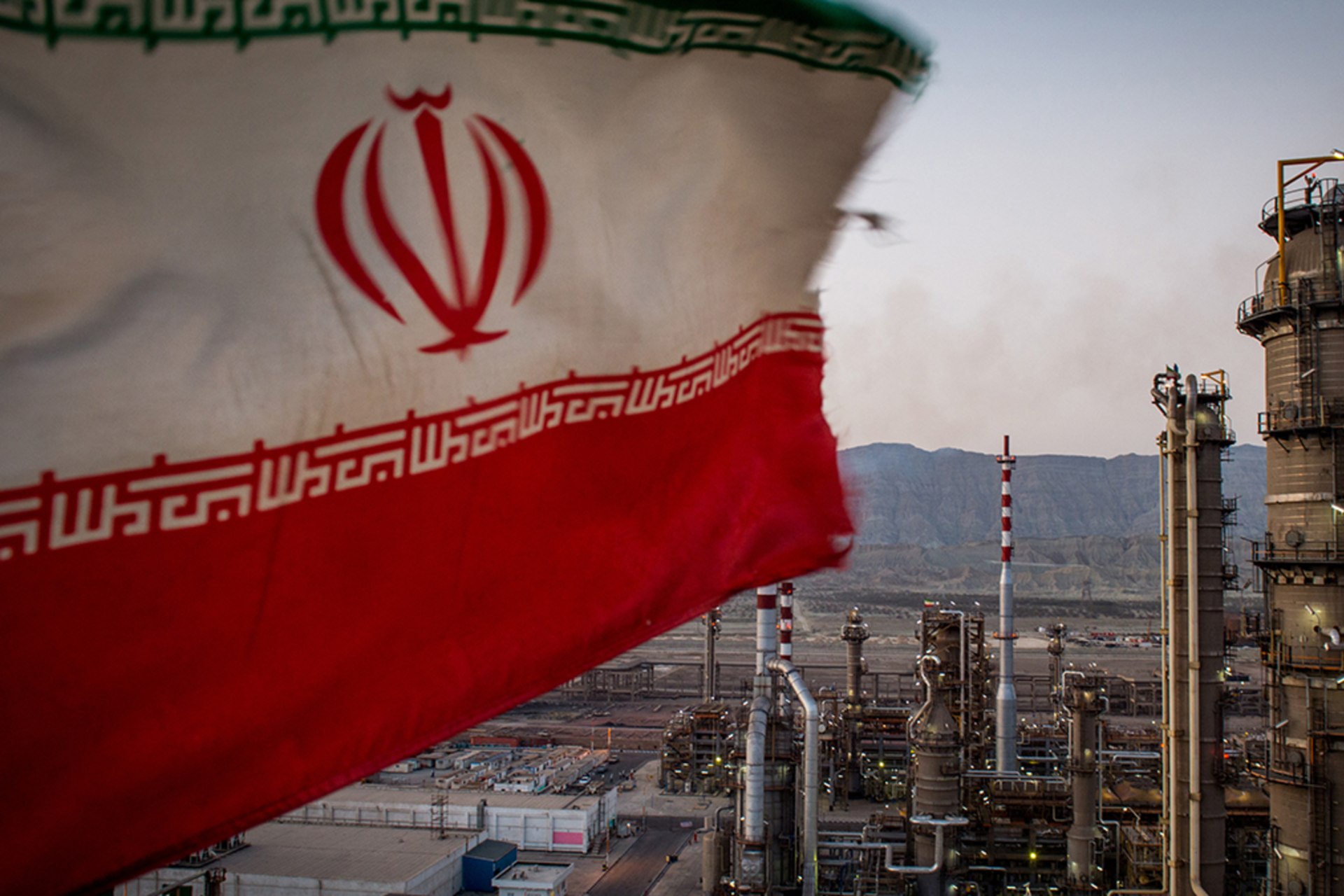 <p>An Iranian national flag flies over a refinery in Bandar Abbas, Iran.</p>