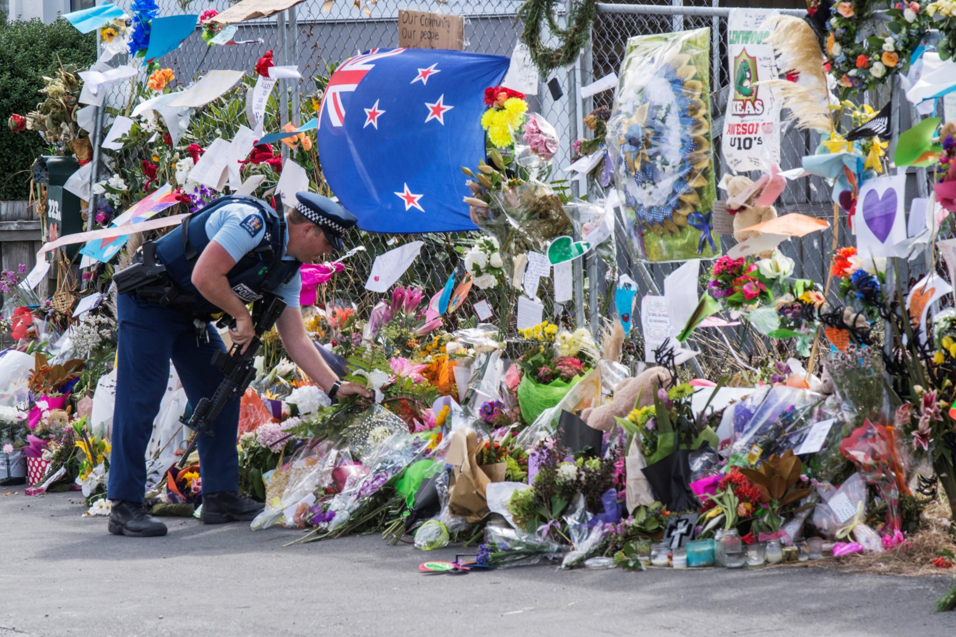<p>A police officer places flower at a memorial for the victims of the mosque shooting in Christchurch, New Zealand, March 22, 2019.</p>
