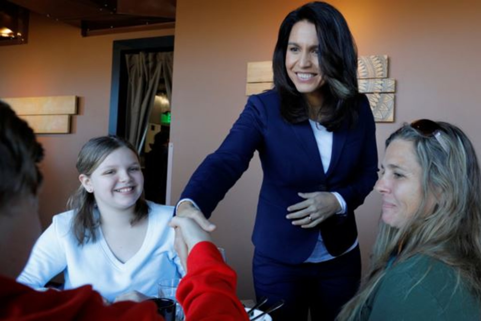 <p>Tulsi Gabbard greets diners during a campaign stop at the Green Elephant in Portsmouth, New Hampshire.</p>
