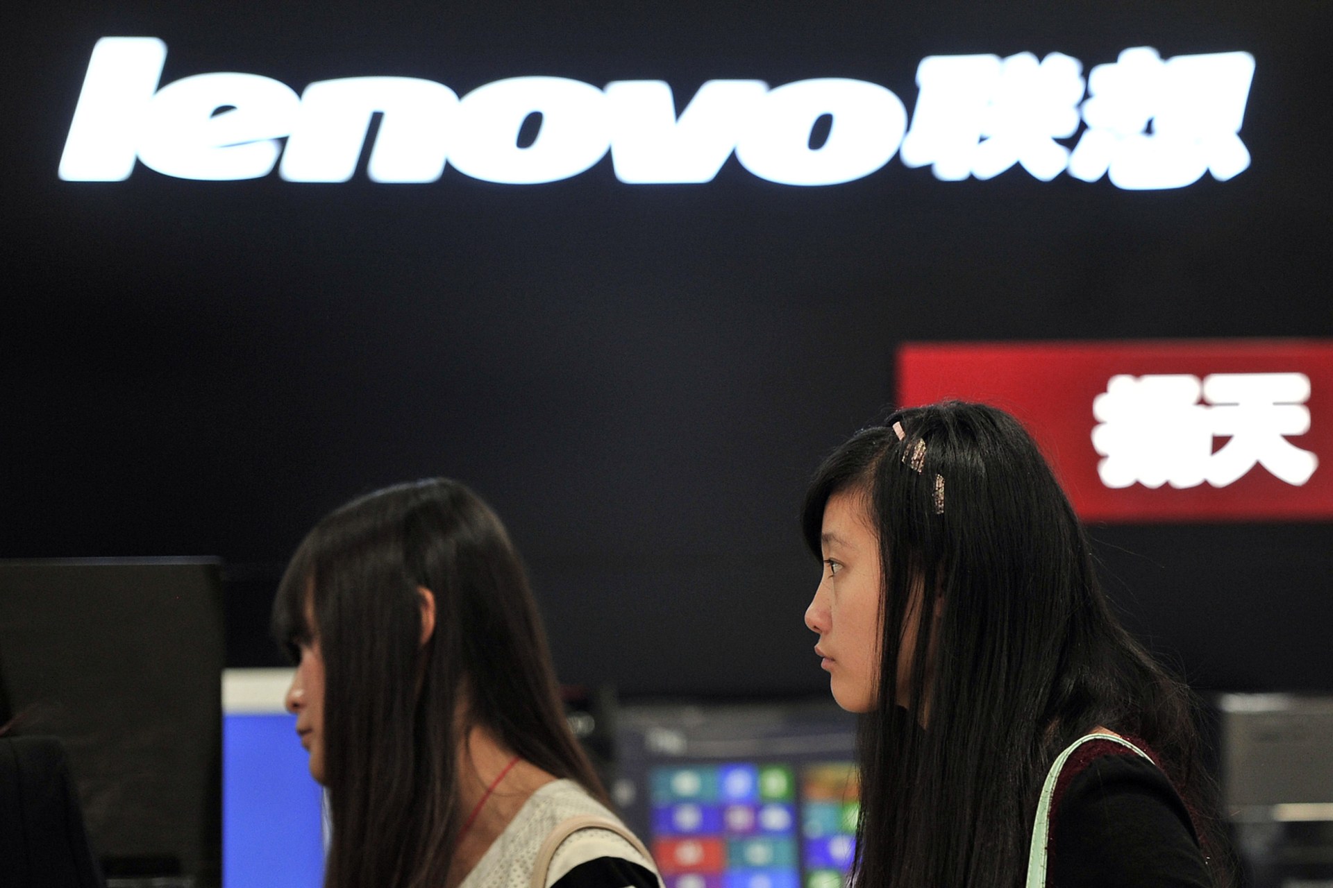 <p>People walk past a Lenovo shop in Hefei, Anhui province</p>
