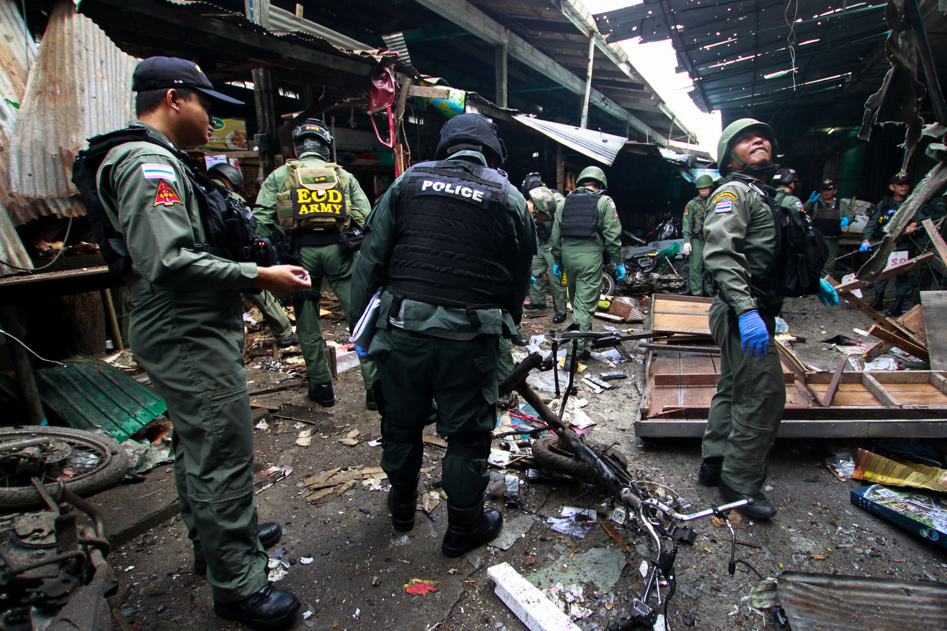 <p>Military personnel and police officers inspect the site of a bomb attack at a market in the southern province of Yala, Thailand, on January 22, 2018. </p>

