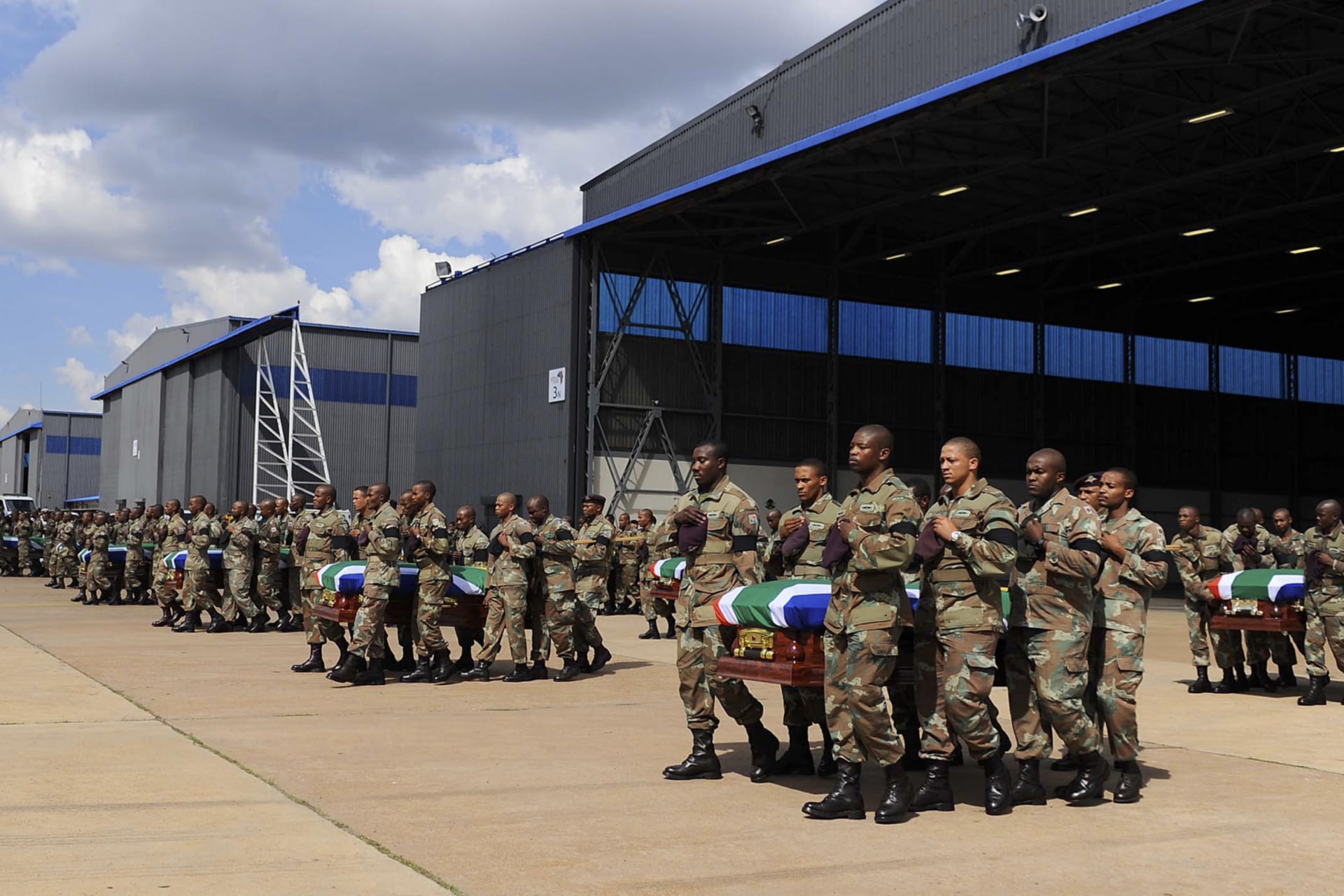 <p>Members of the South Africa National Defense Force (SANDF) carry the remains of 13 members that were killed in Central African Republic (CAR) during the handing over to the respective families at the Waterkloof Air Force Base, Pretoria, on March 28, 2013.</p>
