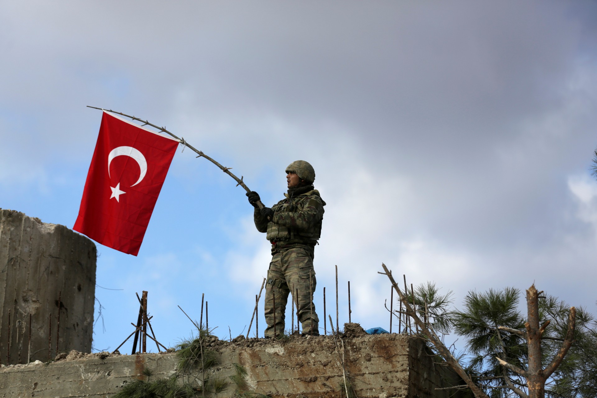 <p>A Turkish soldier waves a flag on Mount Barsaya, northeast of Afrin, Syria January 28 ,2018. </p>