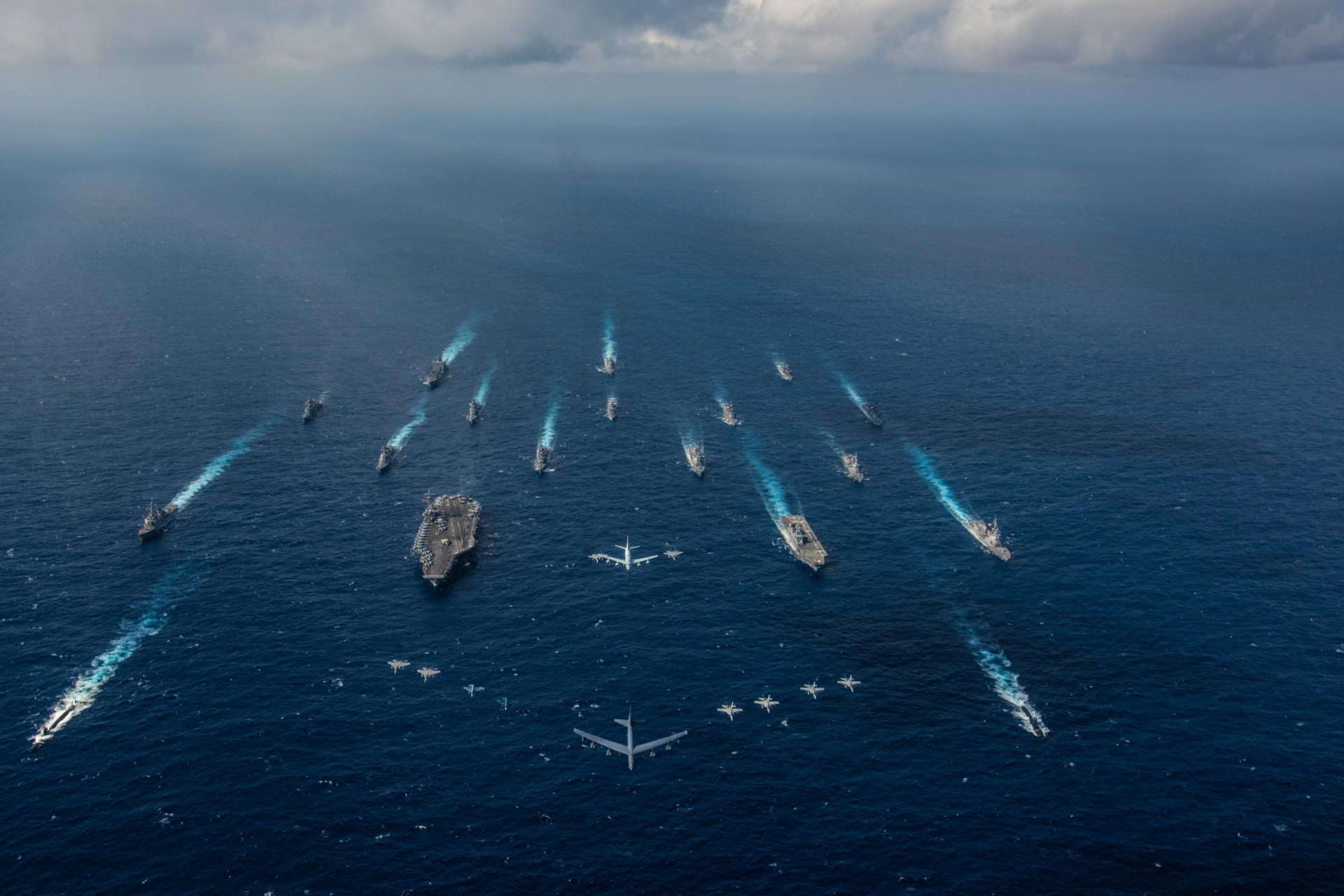 <p>Ships from the U.S. Navy and the Japan Maritime Self-Defense Force sail as aircraft from the U.S. Air Force and Japan Air Self-Defense Force fly overhead in the Philippine Sea on November 8, 2018.</p>
