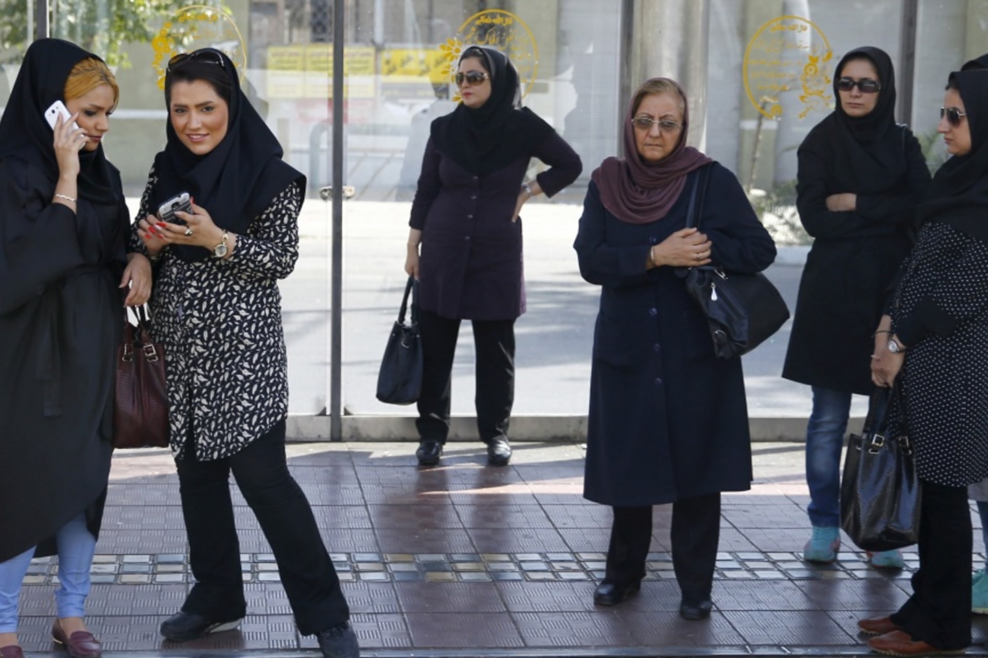 <p>Women wait for a bus in central Tehran, Iran.</p>