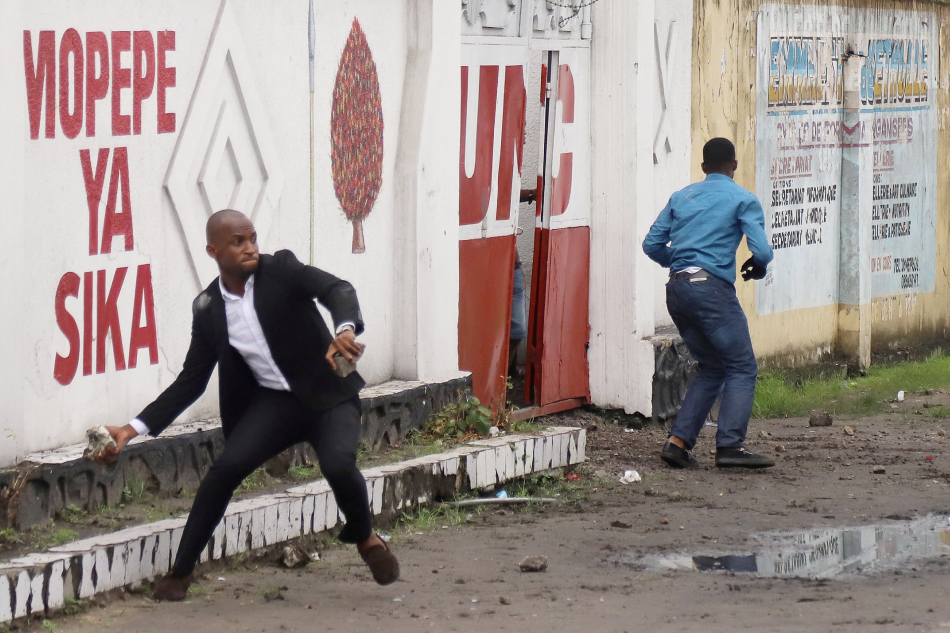 <p>A man hurls stones during clashes between supporters of political rivals in Kinshasa, Democratic Republic of Congo, on November 12, 2018.</p>
