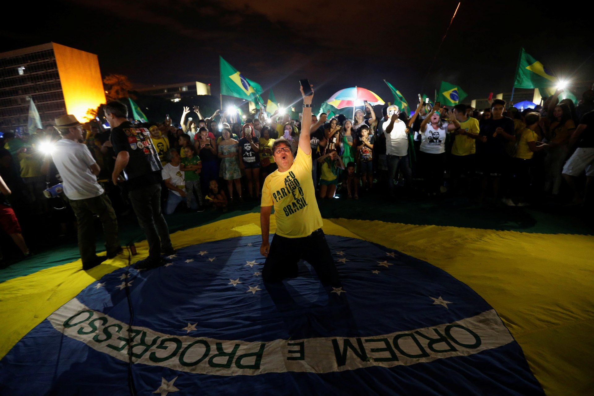 <p>Supporters of Jair Bolsonaro, far-right lawmaker and presidential candidate of the Social Liberal Party, react after Bolsonaro wins the presidential race, in Brasilia on October 28, 2018.</p>
