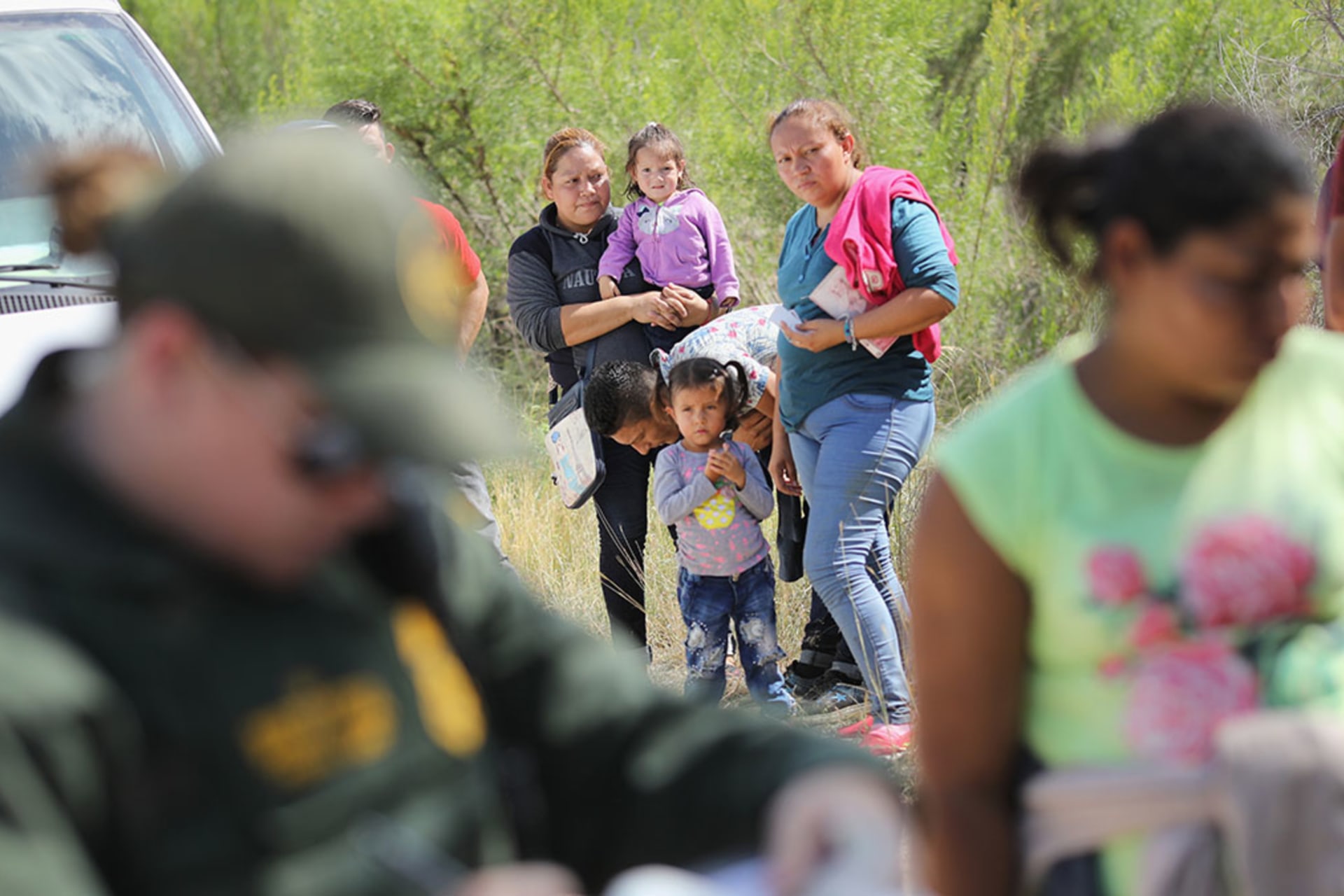 <p>Central American asylum seekers wait as U.S. Border Patrol agents take them into custody near McAllen, Texas. The families were then sent to a U.S. Customs and Border Protection (CBP) processing center for possible separation.</p>
