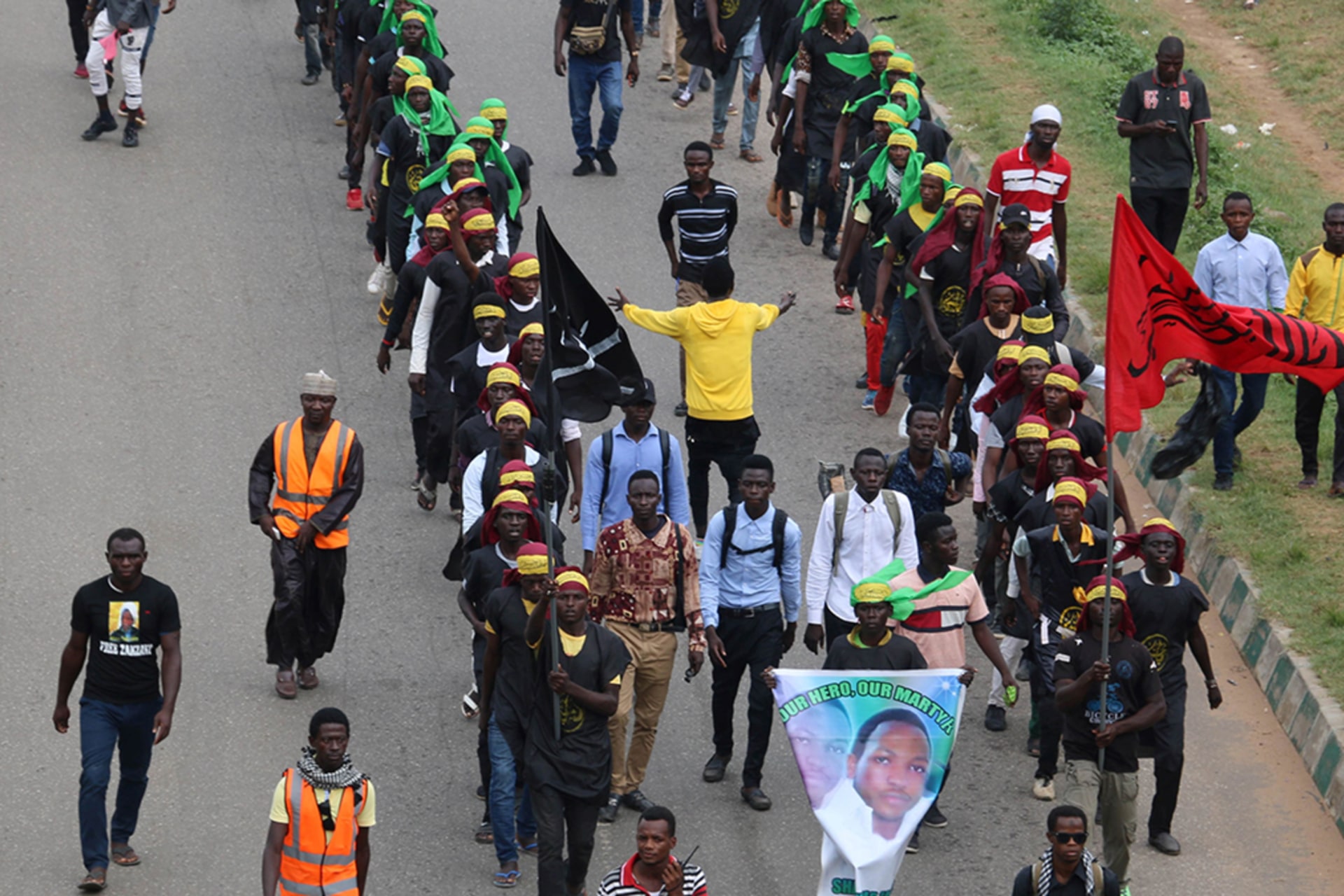 <p>Members of Islamic Movement of Nigeria (IMN) wave flags and chant slogans as they take part in a demonstration to protest against an imprisoned Shiite cleric, in Abuja, on October 29, 2018.</p>
