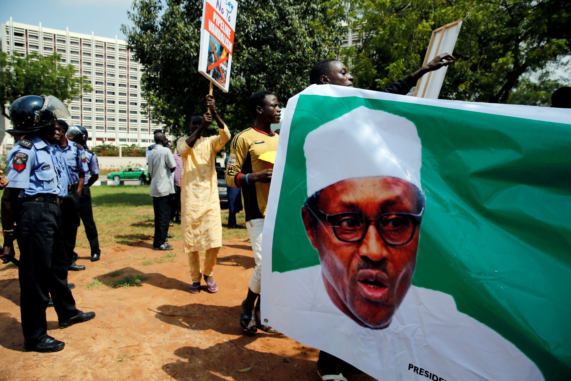<p>Supporters of President Muhammadu Buhari rally in support of his administration as police officers look on, at the Unity fountain in Abuja, Nigeria, on August 11, 2017.</p>
