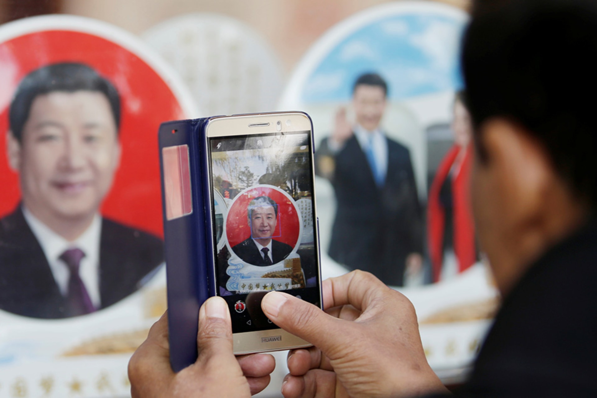 <p>During the Nineteenth Party Congress of the Chinese Communist Party in Beijing in 2017, a tourist photographs a souvenir plate featuring Chinese President Xi Jinping in a shop near Tiananmen Square.</p>
