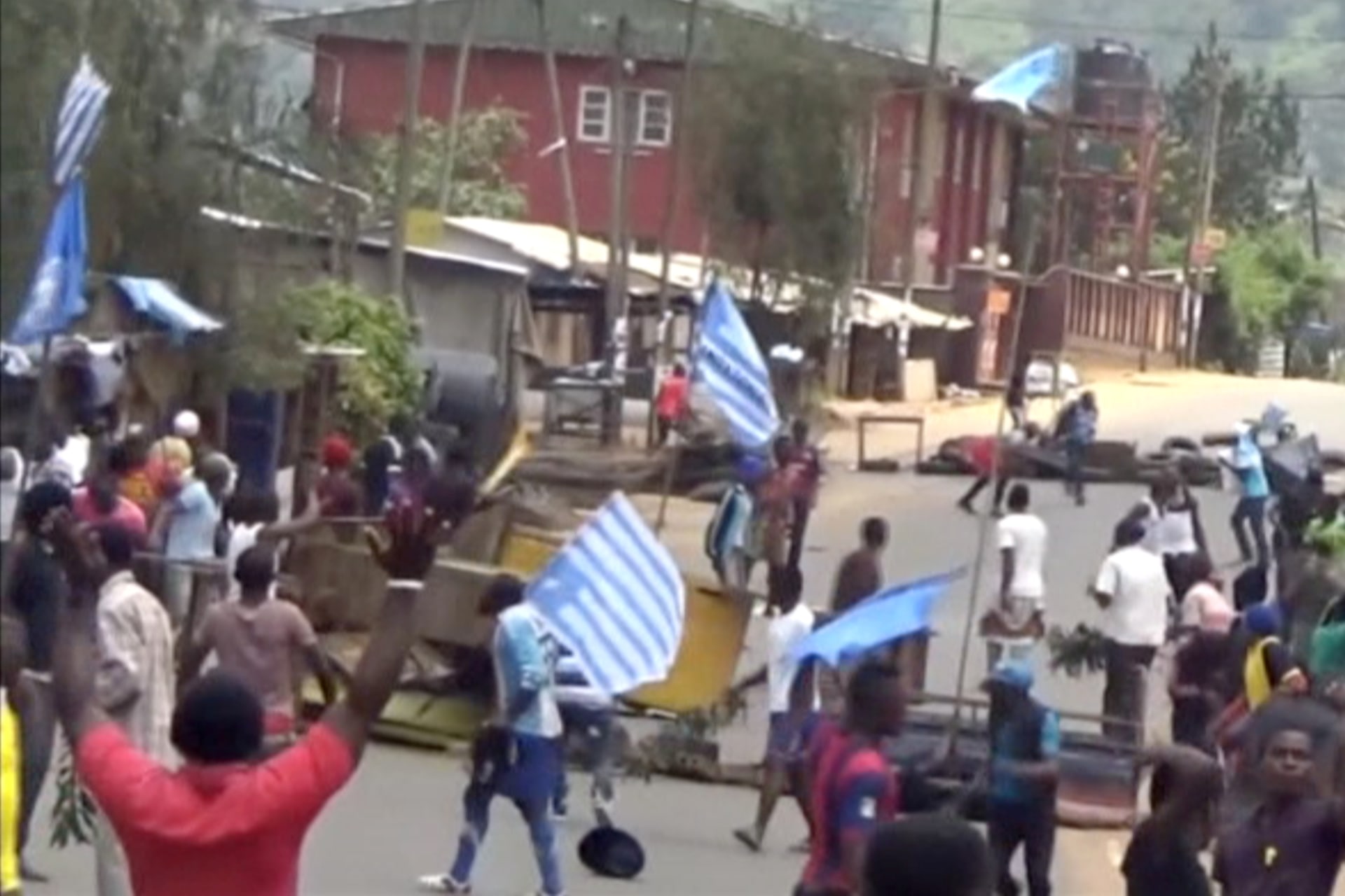 <p>A still image taken from a video shot on October 1, 2017, shows protesters waving Ambazonian flags in front of road block in the English-speaking city of Bamenda, Cameroon. </p>