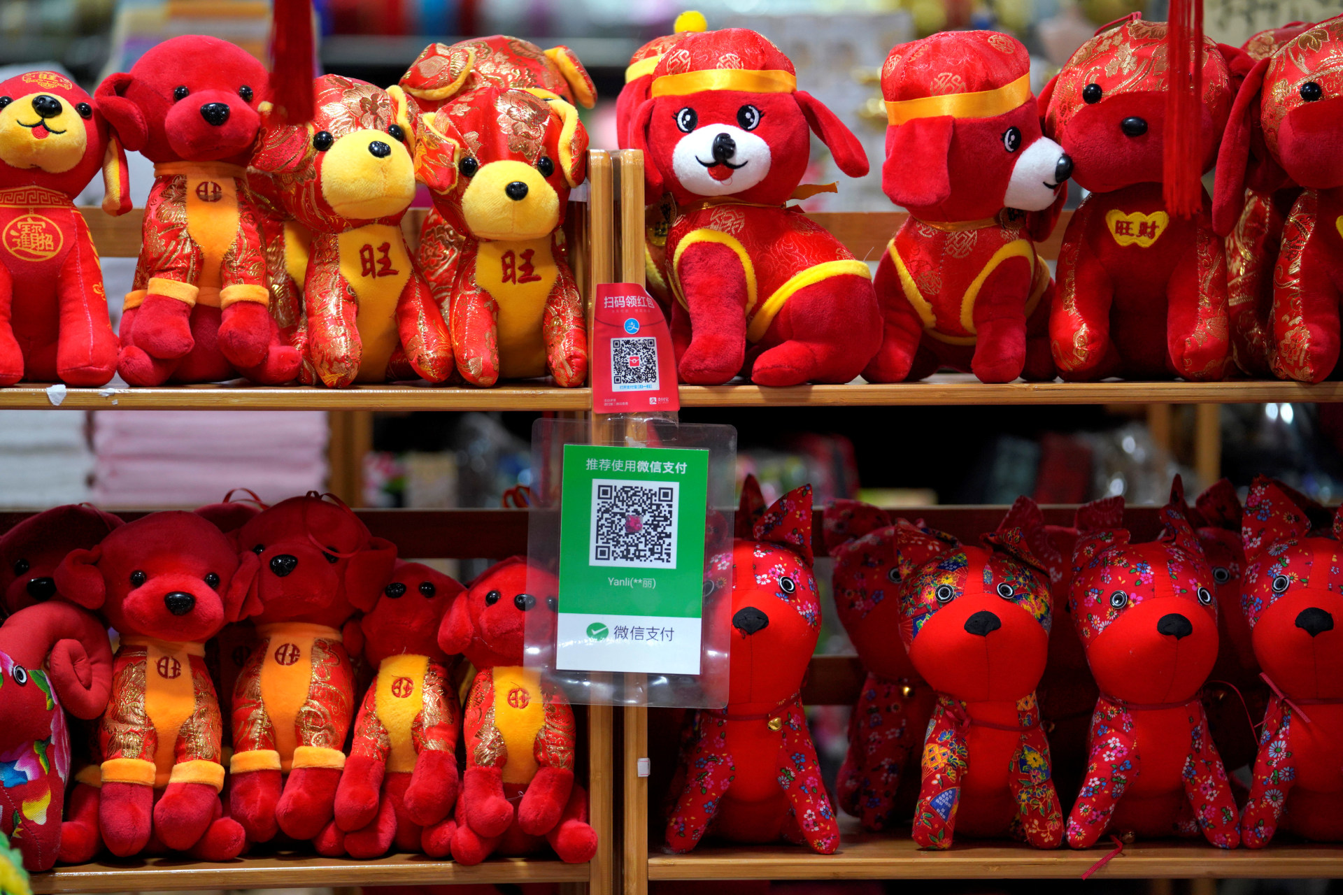 <p>QR codes of Alipay (top) and Wechat Pay are seen next to toys displayed for sale at a shop ahead of the Lunar Year of the Dog in Beijing, China on February 8, 2018. </p>
