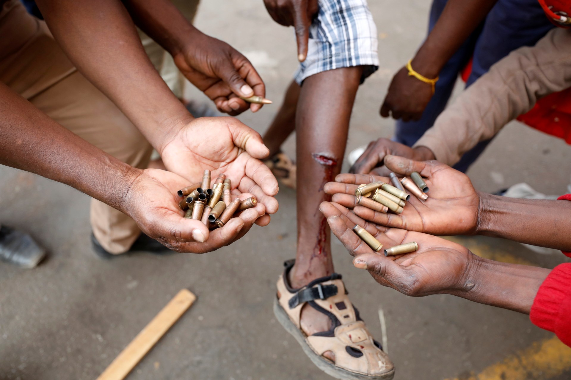 <p>Opposition Movement for Democratic Change supporters hold spent rounds and show injuries after soldiers opened fire outside the party’s headquarters in Harare, Zimbabwe, August 1, 2018.</p>
