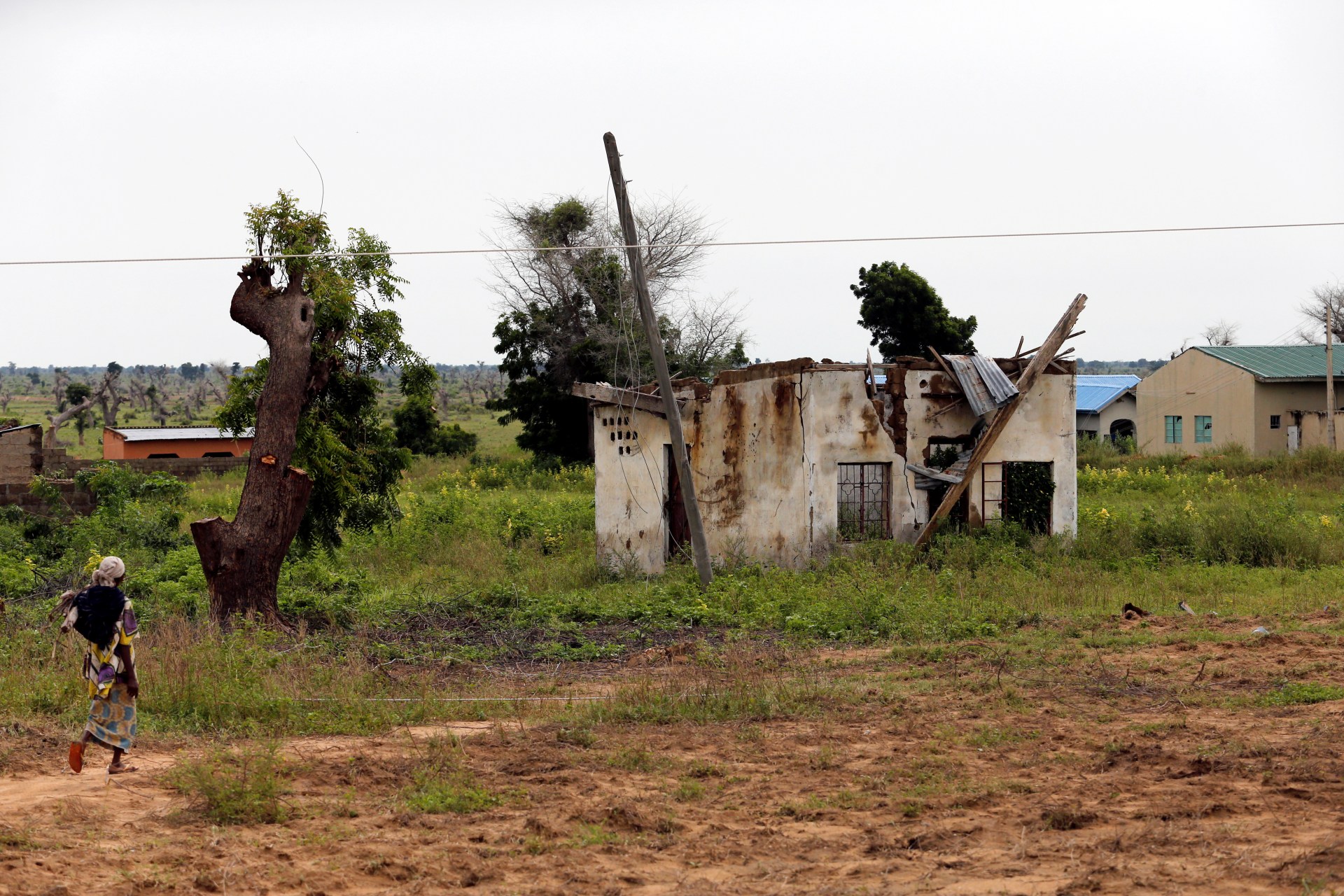 <p>A woman walks toward a house damaged by Boko Haram militants, along the Konduga-Bama road in Bama, Borno, Nigeria, August 31, 2016.</p>