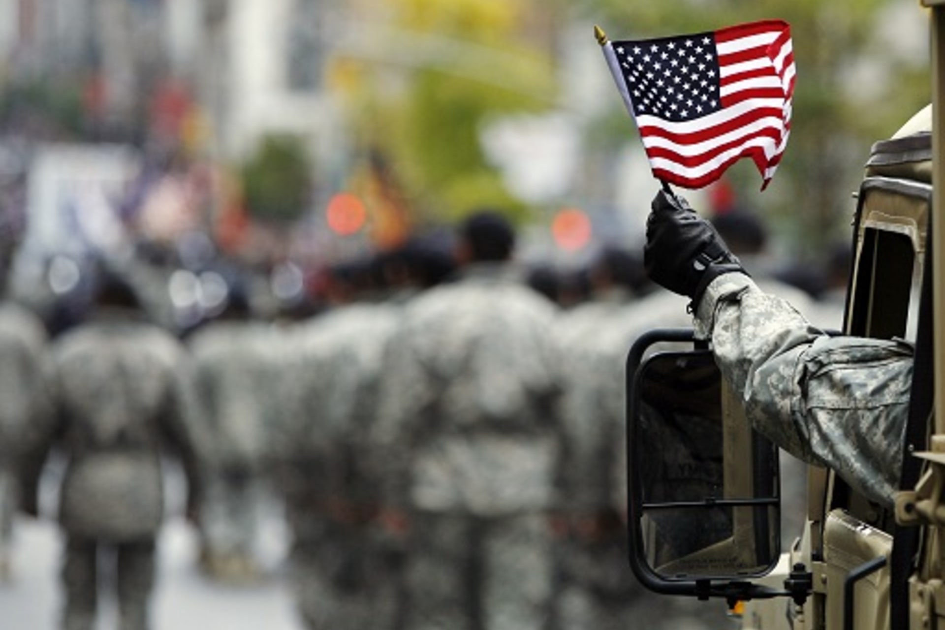 <p>U.S. Army serviceman waves an American flag during a Veterans Day parade in New York. </p>

