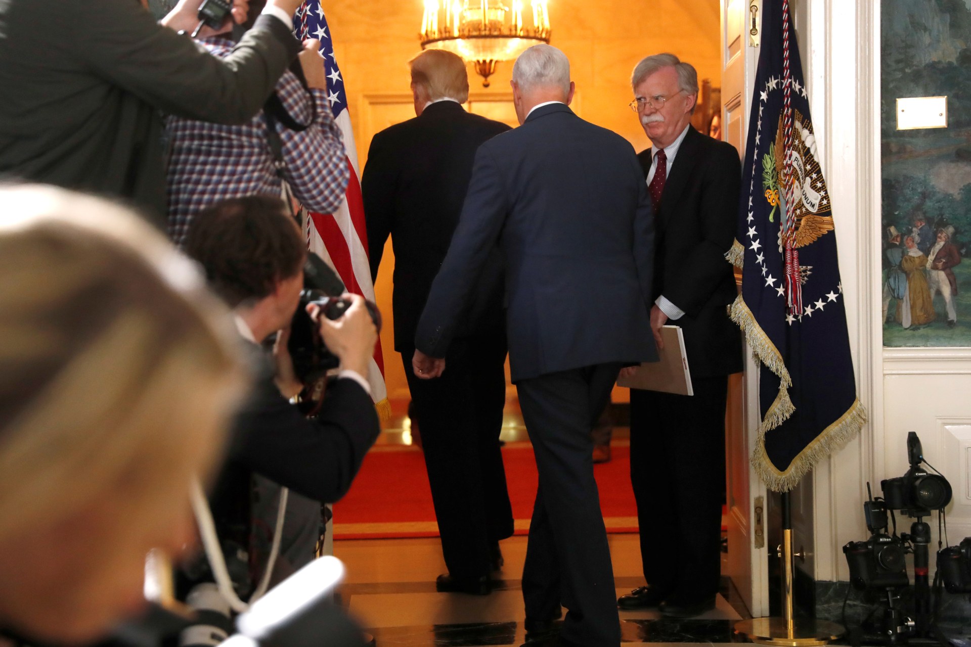 <p>White House National Security Advisor John Bolton (R) departs with U.S. President Donald Trump and Vice President Mike Pence after Trump announced his intention to withdraw from the Iran nuclear agreement on May 8, 2018.</p>