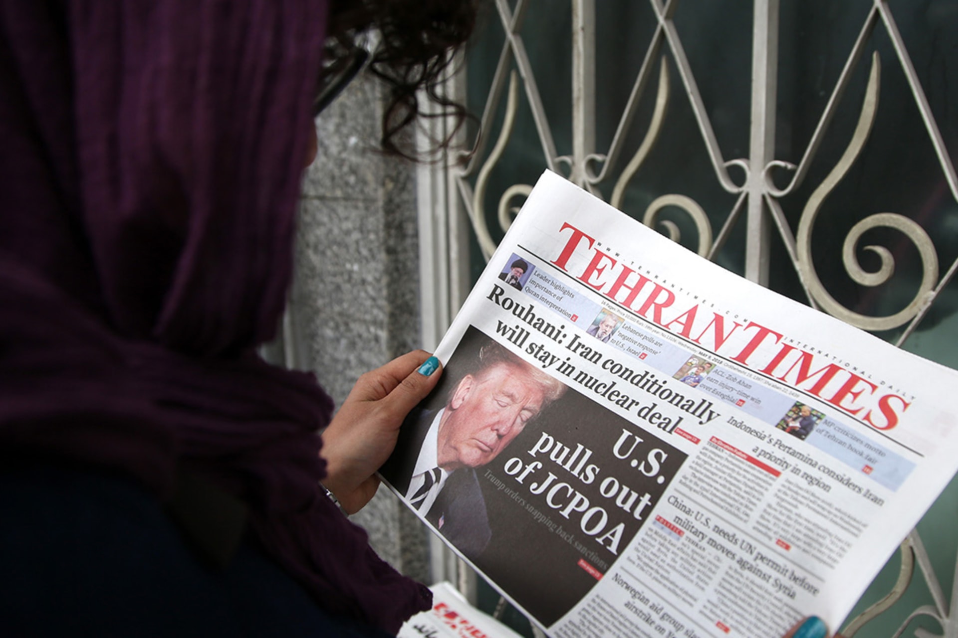 <p>A woman reads the Tehran Times, May 9, 2018.</p>