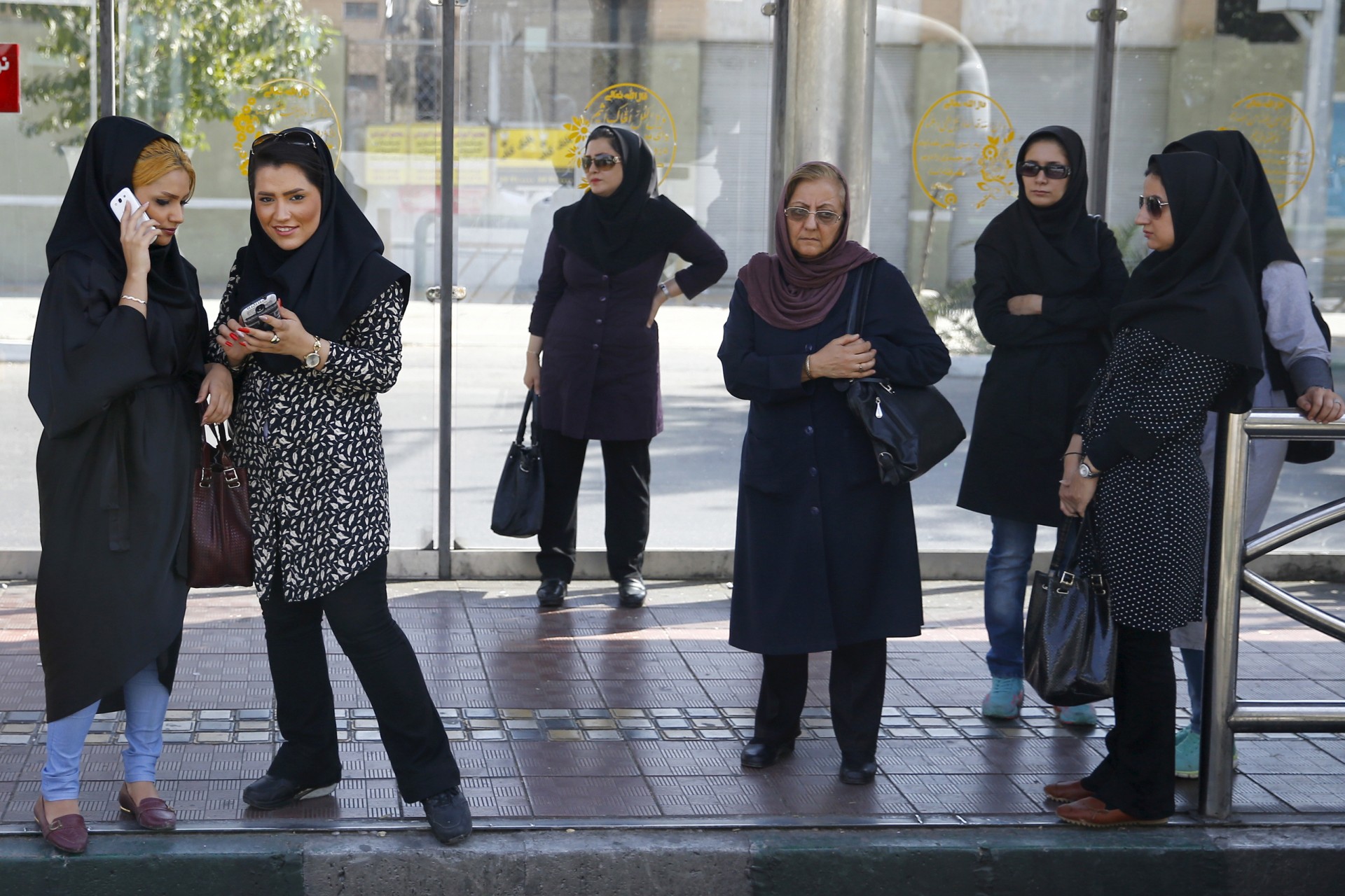 <p>Women wait for a bus in central Tehran, Iran.</p>