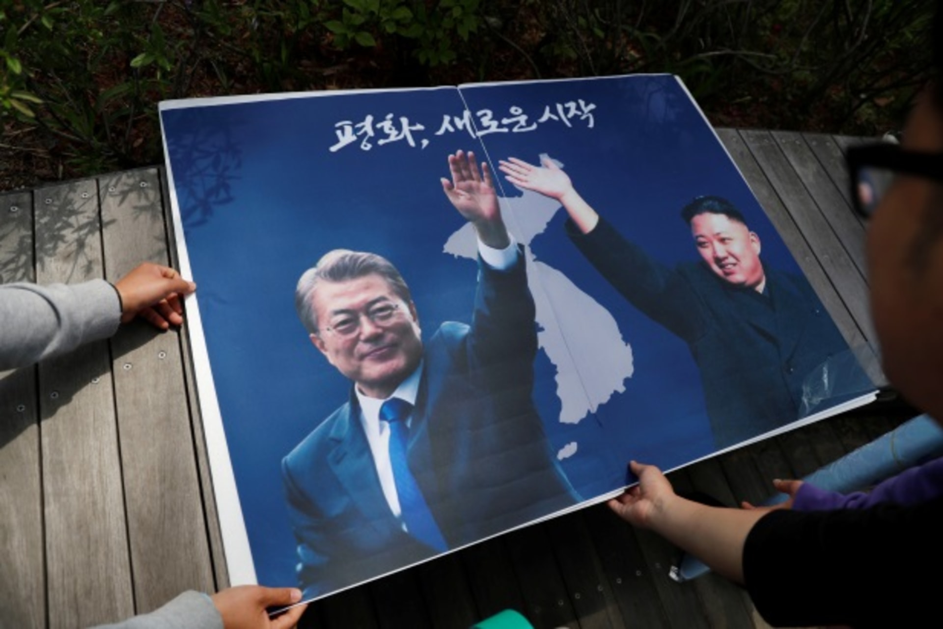 <p>Students hold posters with pictures of South Korea’s President Moon Jae-in and North Korea’s leader Kim Jong Un during a pro-unification rally ahead of the upcoming summit between North and South Korea in Seoul, South Korea April 26, 2018.</p>
