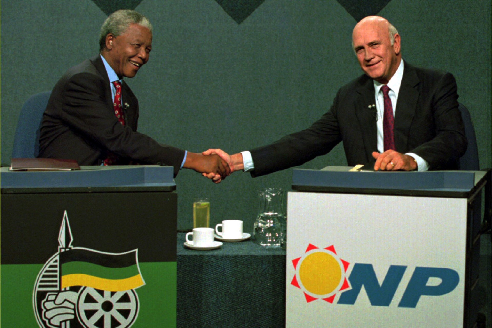 <p>South African President F.W. de Klerk (R) shakes hands with African National Congress (ANC) President Nelson Mandela during a televised debate April 14, 1994.</p>

