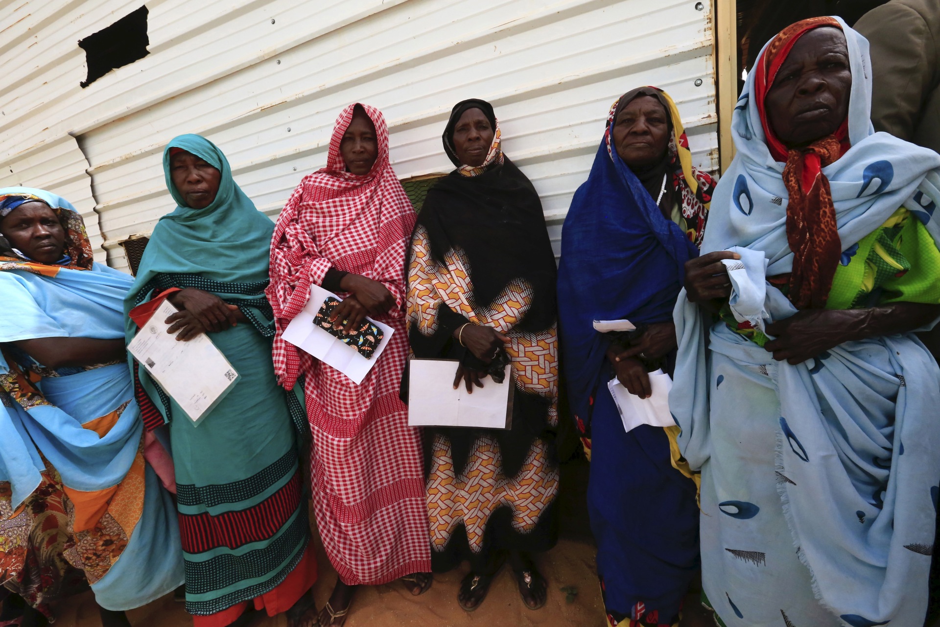 <p>Women carry identification papers during the registration for a Darfur referendum, at a registration centre at Abo-Shouk IDP camp at Al Fashir in North Darfur, February 17, 2016.</p>