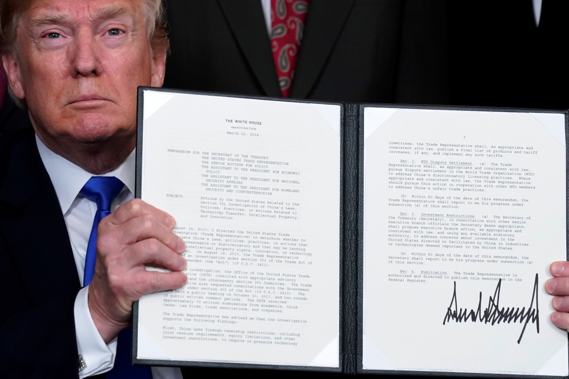 <p>U.S. President Donald Trump holds a signed memorandum on intellectual property tariffs on high-tech goods from China, at the White House on March 22, 2018.</p>
