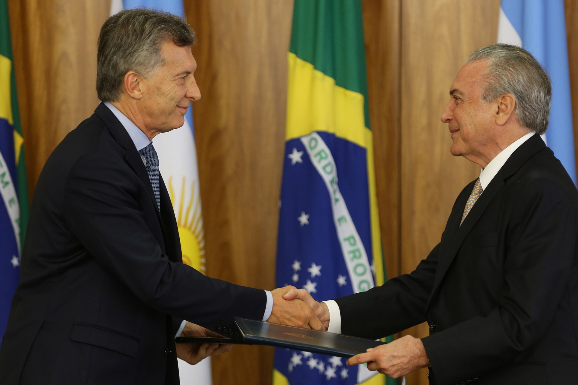 <p>Argentine President Mauricio Macri (L) and his Brazilian counterpart Michel Temer exchange documents after a meeting to discuss closer trade cooperation at the Planalto Palace in Brasilia, Brazil February 7, 2017. </p>
