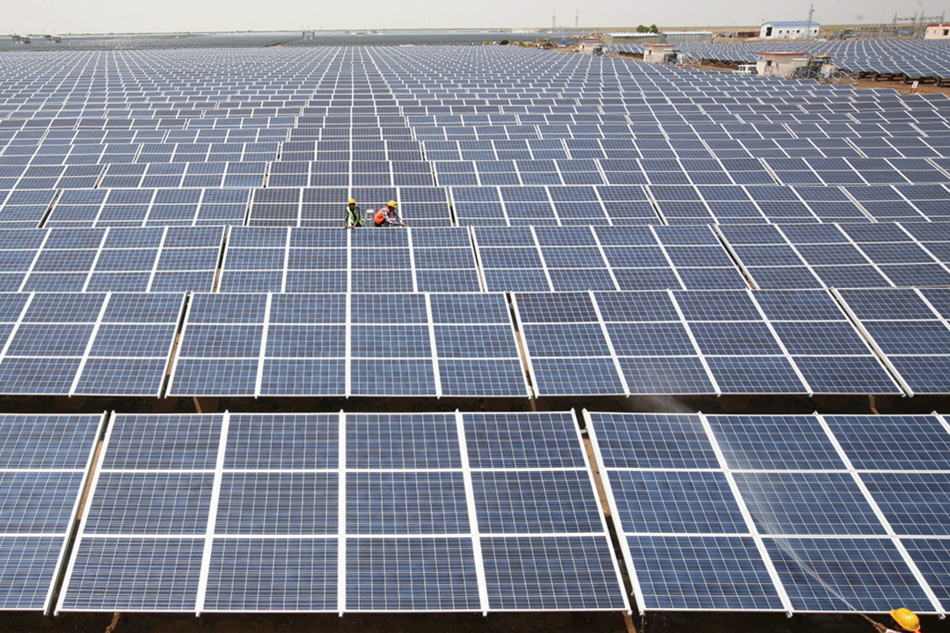 <p>Workers install photovoltaic solar panels at the Gujarat solar park under construction in Charanka village, in Patan district of the western Indian state of Gujarat, India, April 14, 2012.</p>
