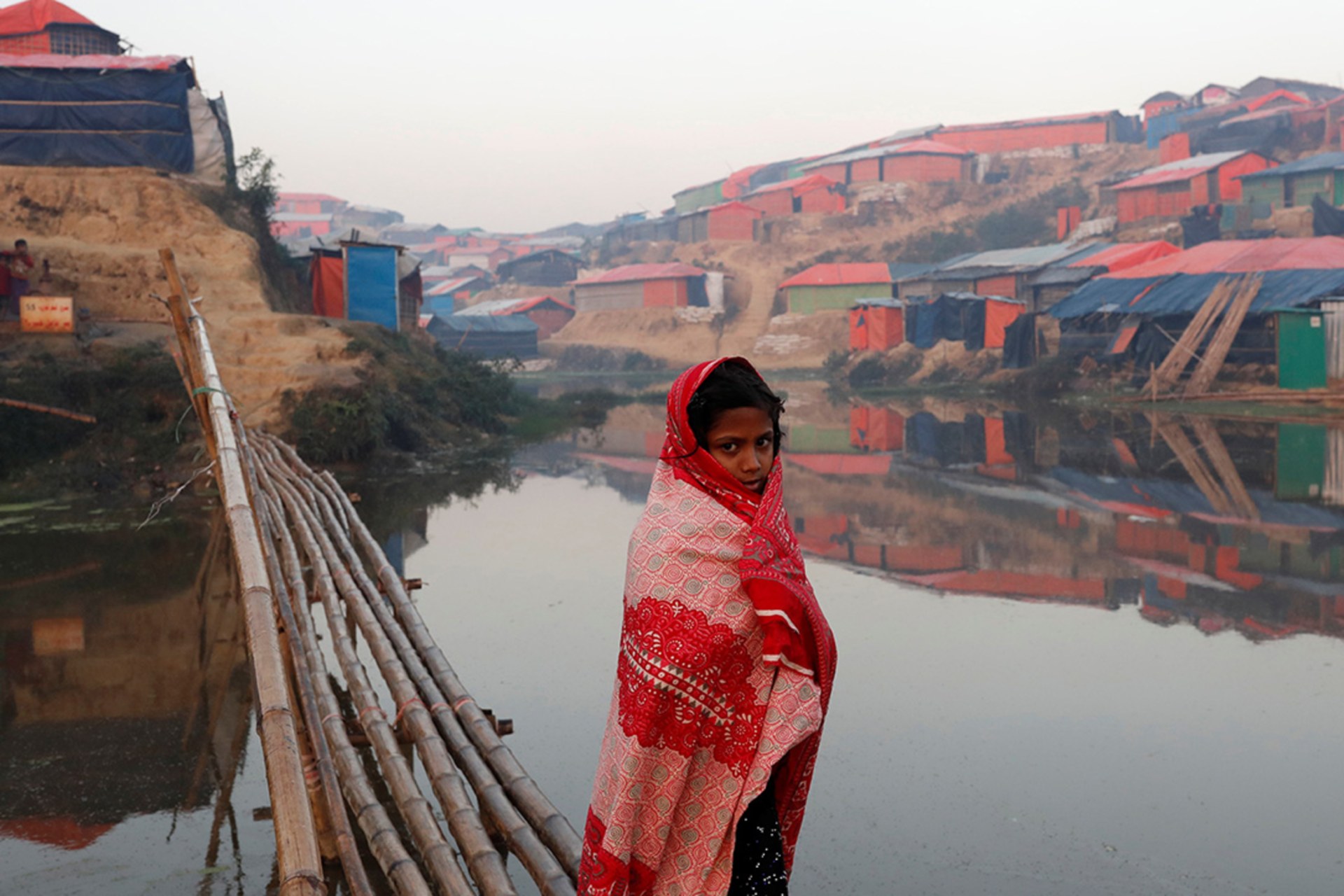 <p>A Rohingya refugee girl walks next to a pond in the early morning at Balukhali refugee camp near Cox’s Bazar, Bangladesh, on January 10, 2018.</p>
