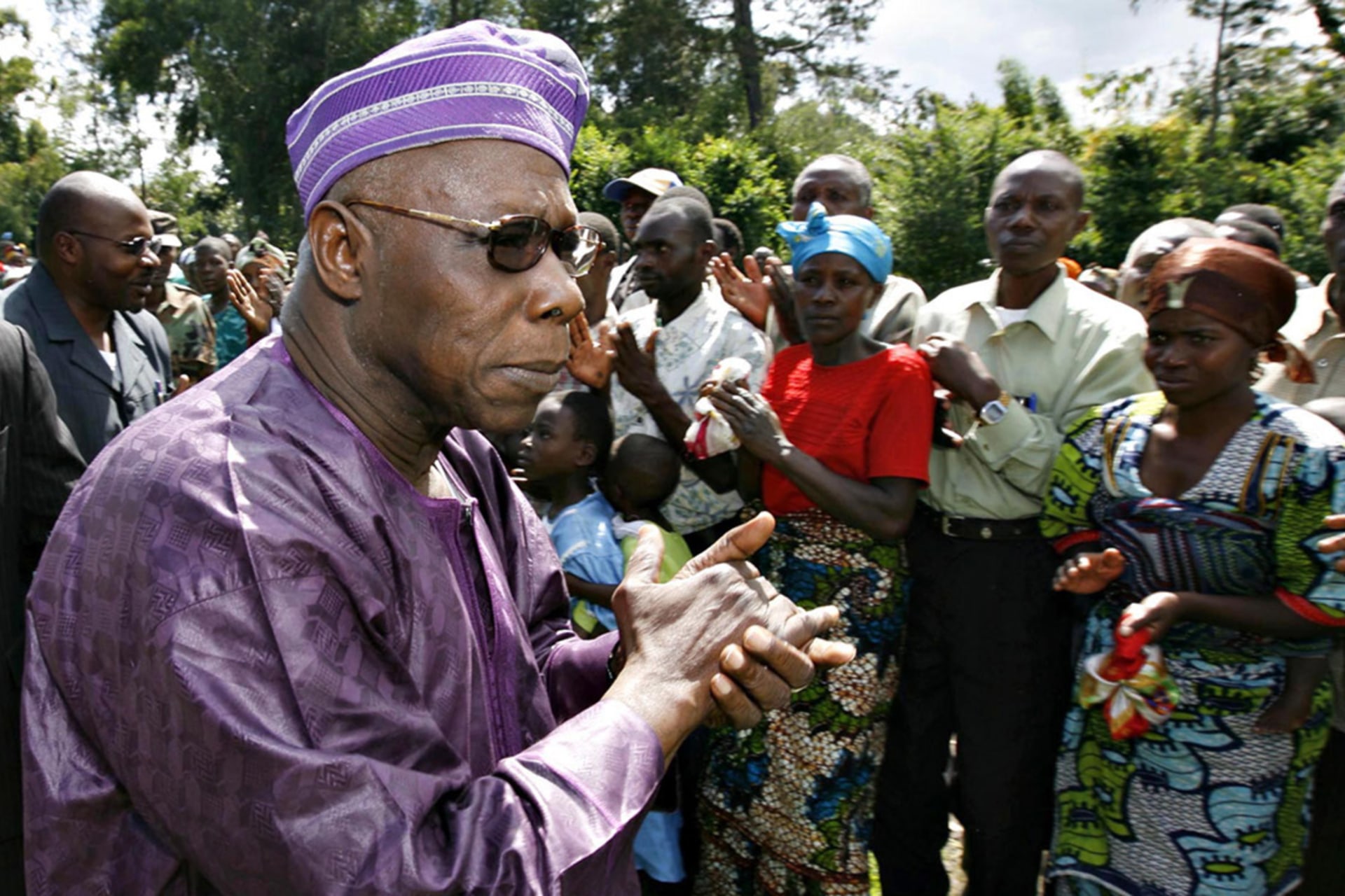 <p>Former Nigerian President Olusegun Obasanjo greets people as he arrives to meet rebels in the village of Jnomba in eastern Congo, November 16, 2008.</p>
