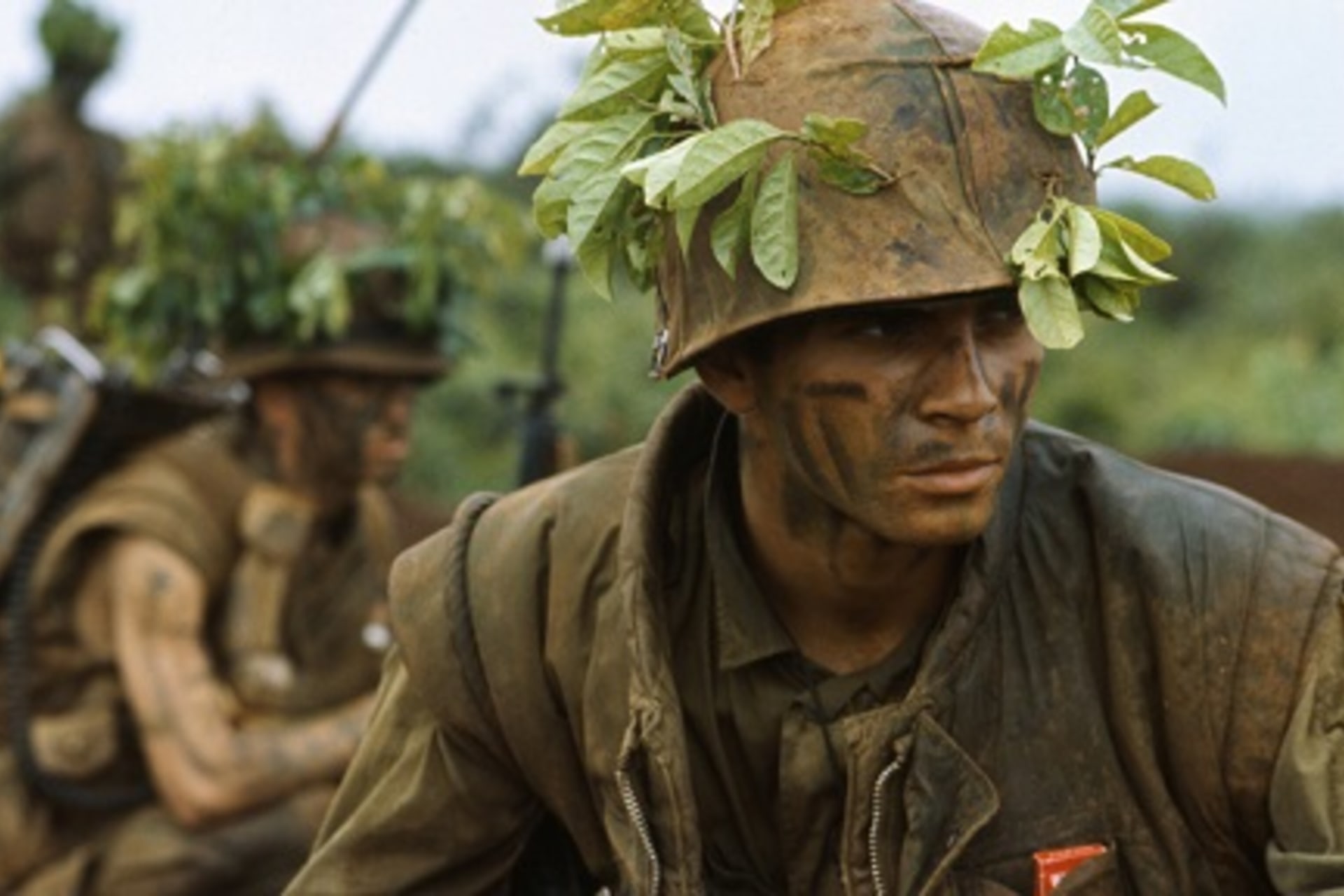 <p>U.S. Marines in camouflage move through low foliage in the Demilitarized Zone of Vietnam. </p>
