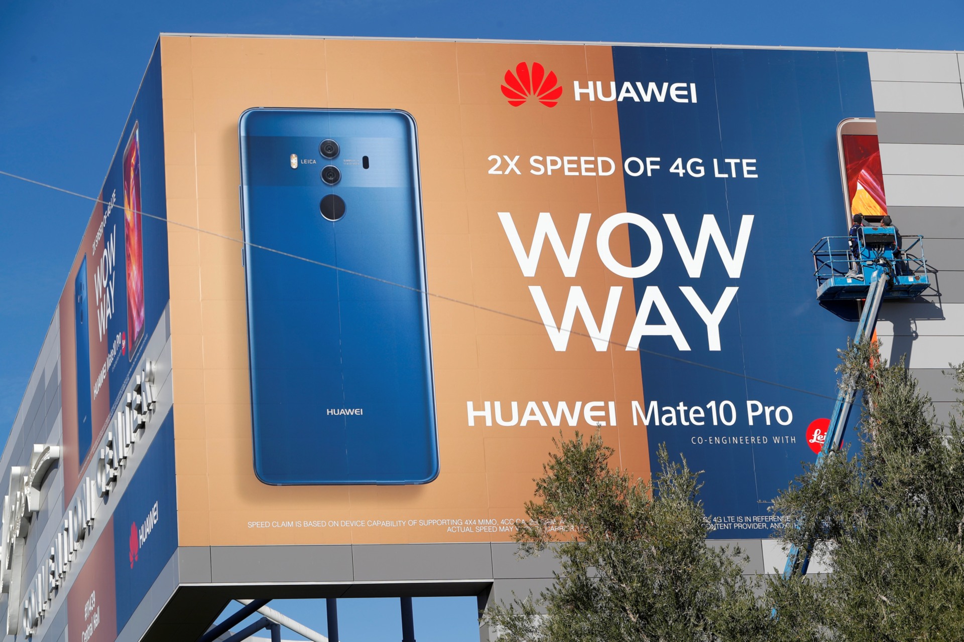 <p>A crew hangs a Huawei advertising banner on the side of the Las Vegas Convention Center as workers prepare for the 2018 CES in Las Vegas, Nevada.</p>