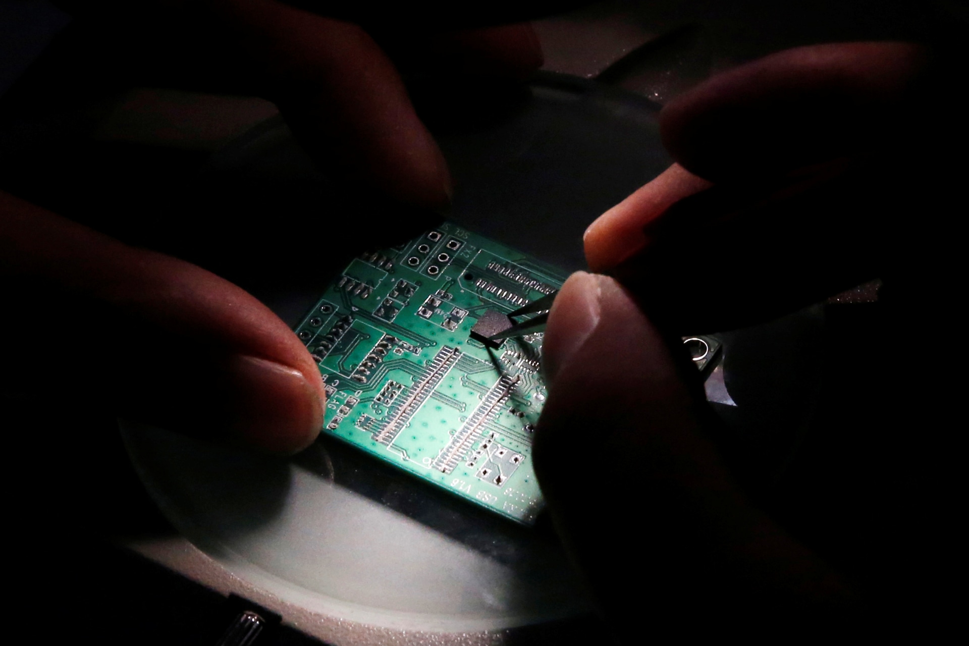 <p>A researcher plants a semiconductor on an interface board which is placed under a microscope during a research work to design and develop a semiconductor product at Tsinghua Unigroup research centre in Beijing, China.</p>