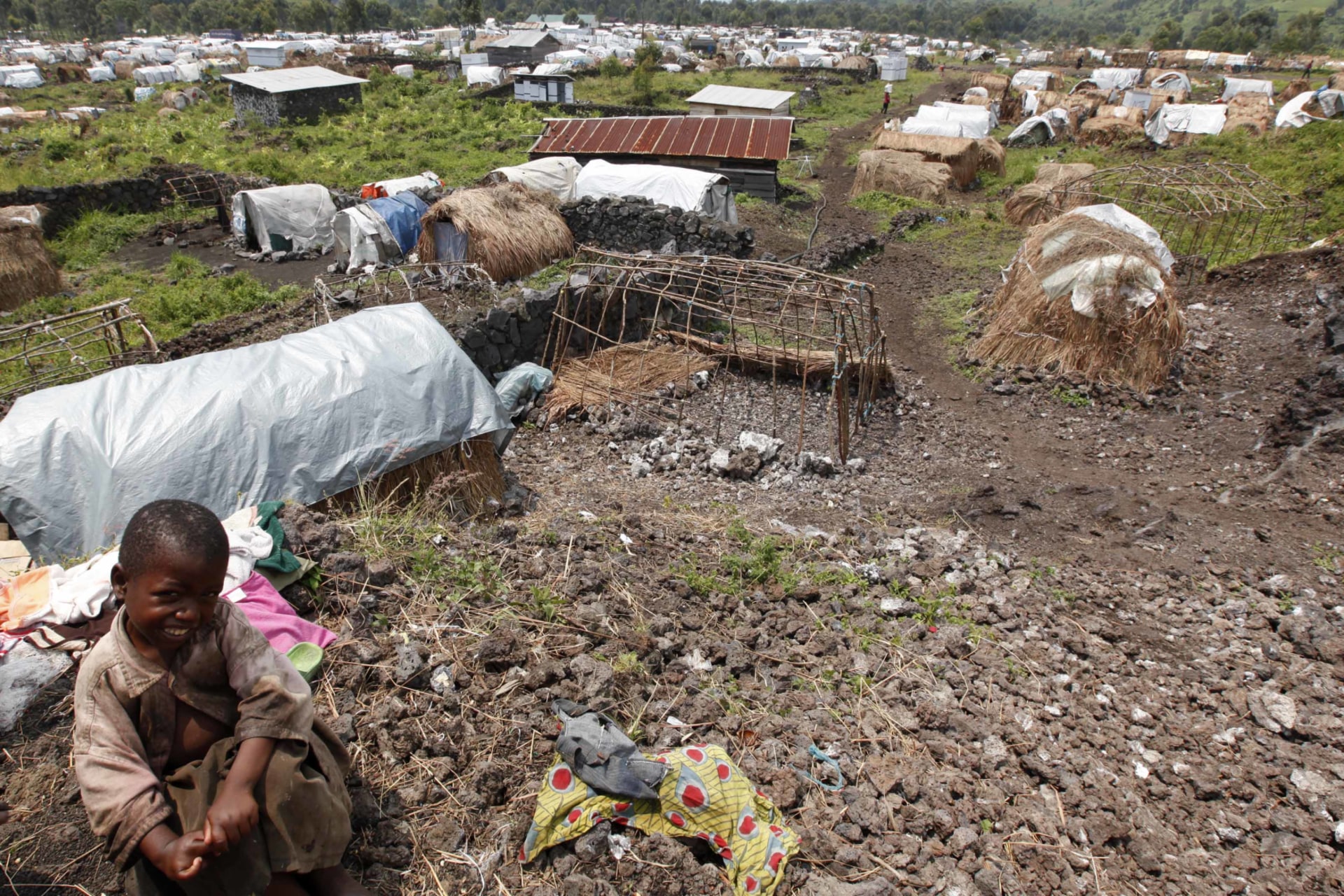 <p>Juane, 5, displaced by fighting in eastern Congo, sits next to her family’s makeshift shelter overlooking Mugunga IDP camp, outside of Goma, November 24, 2012. Originally opened around 2009, that camp is still in operation today.</p>

