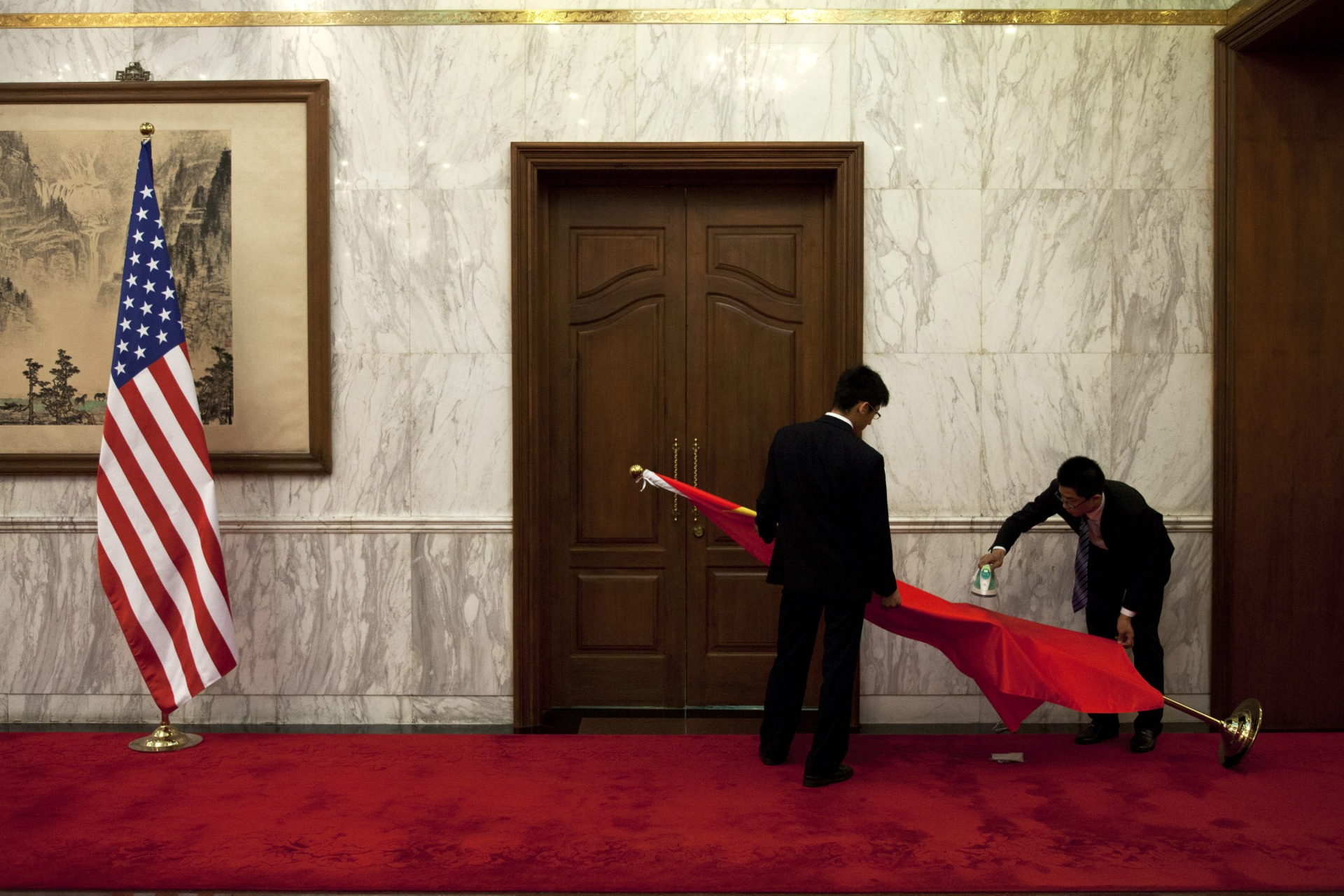 <p>Chinese officials prepare the Chinese flag before a meeting with U.S. officials in 2013.</p>
