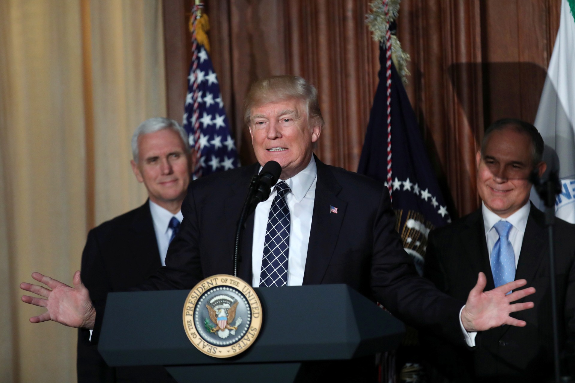 <p>U.S. President Donald Trump speaks between Vice President Mike Pence (L) and EPA Administrator Scott Pruitt prior to signing an executive order on “Energy Independence,” eliminating Obama-era climate change regulations, March 28, 2017.</p>