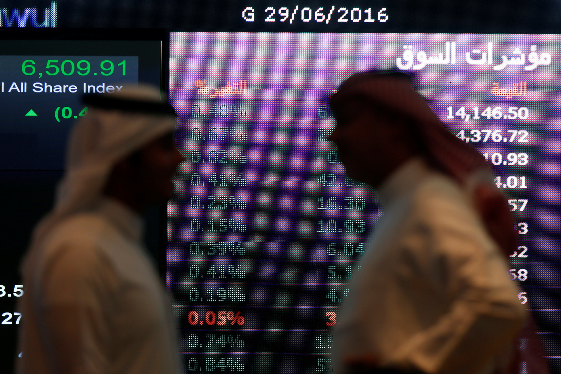 <p>Investors talk with each other as they monitor a screen displaying stock information at the Saudi Stock Exchange (Tadawul) in Riyadh, Saudi Arabia June 29, 2016.</p>