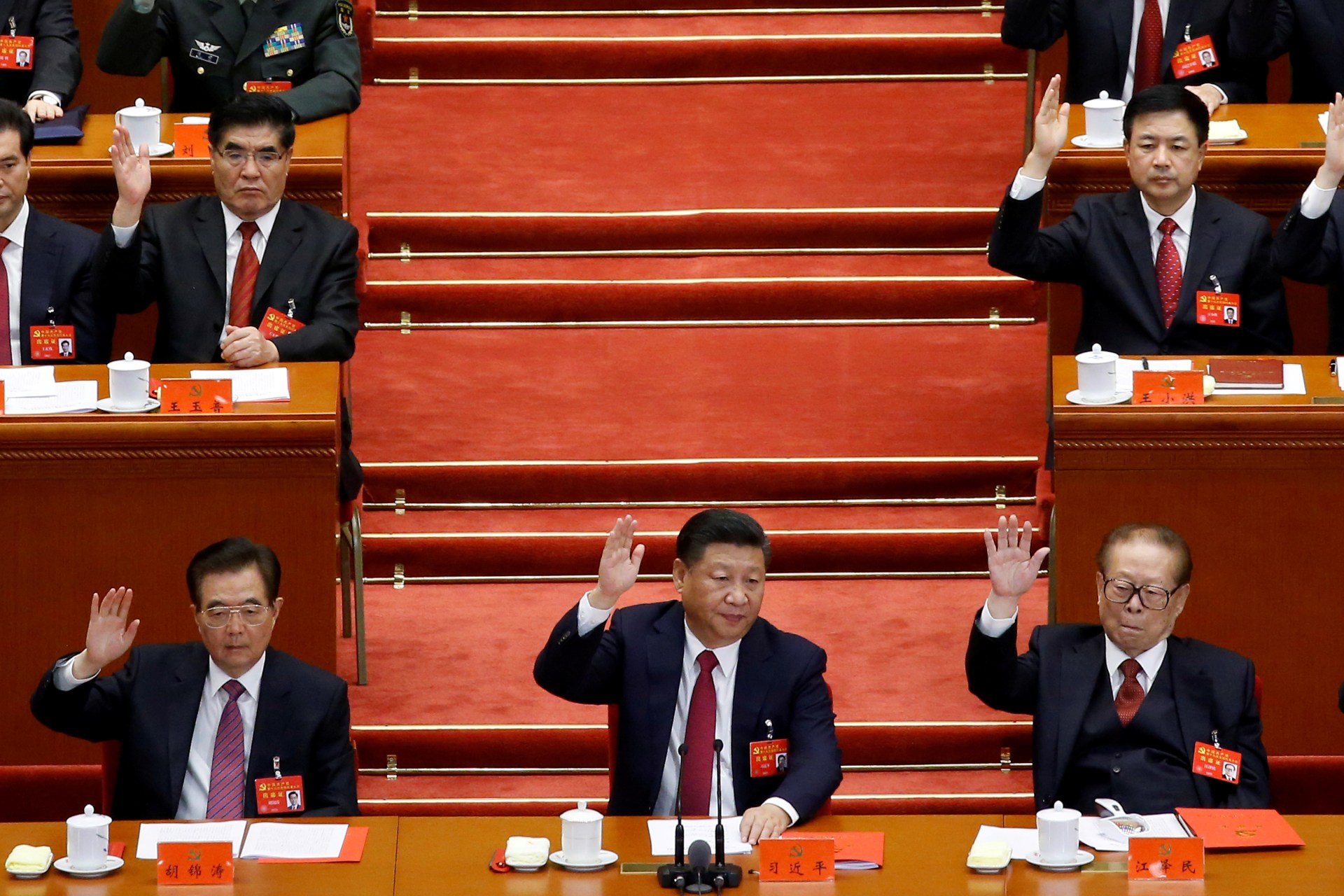 <p>Former Chinese president Hu Jintao, Chinese President Xi Jinping and former Chinese president Jiang Zemin raise their hands as they take a vote at the closing session of the 19th National Congress of the Communist Party of China, in Beijing, China.</p>
