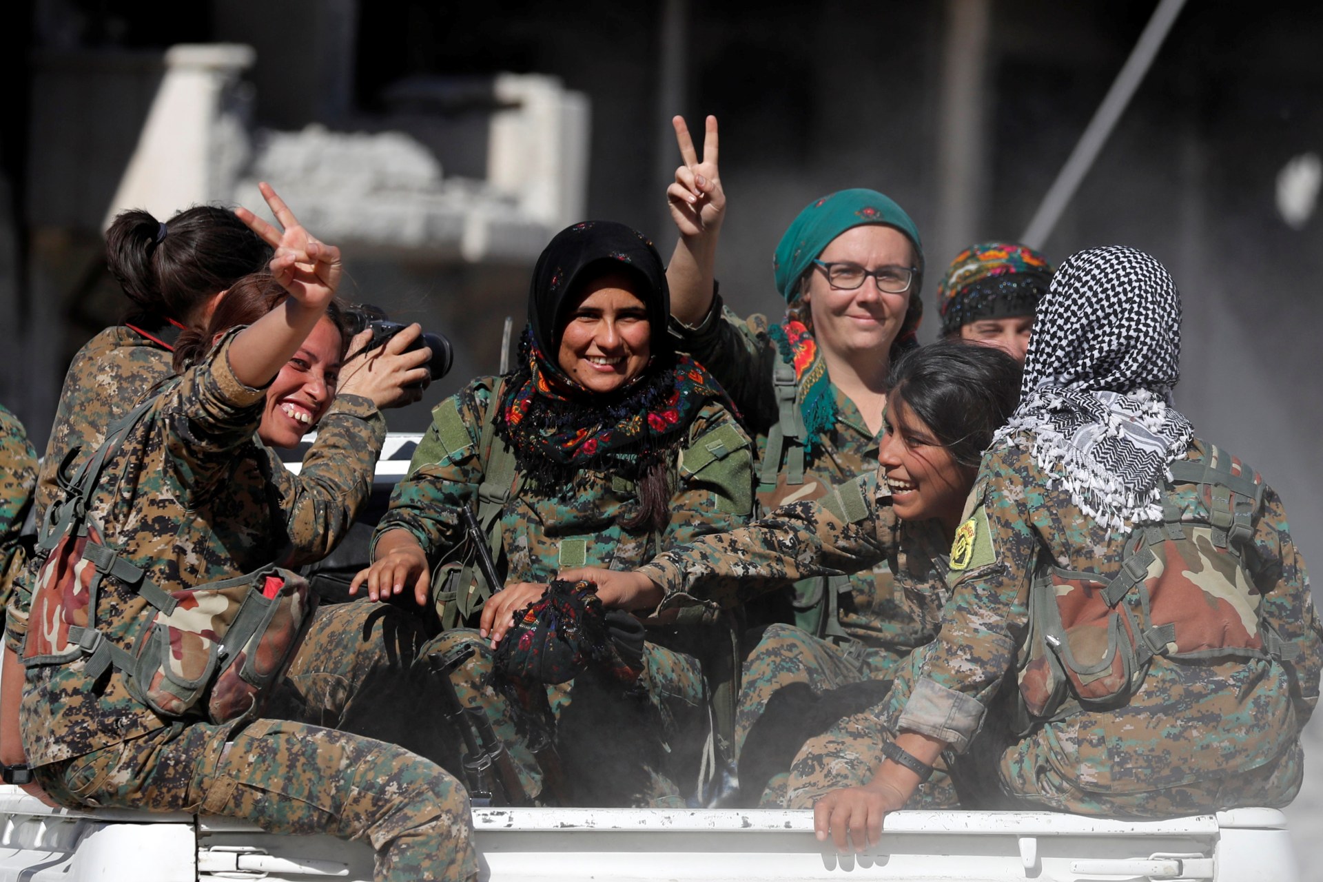 <p>Female fighters of Syrian Democratic Forces gesture the “V” sign while onboard a pick up truck in Raqqa, Syria October 18, 2017. </p>
