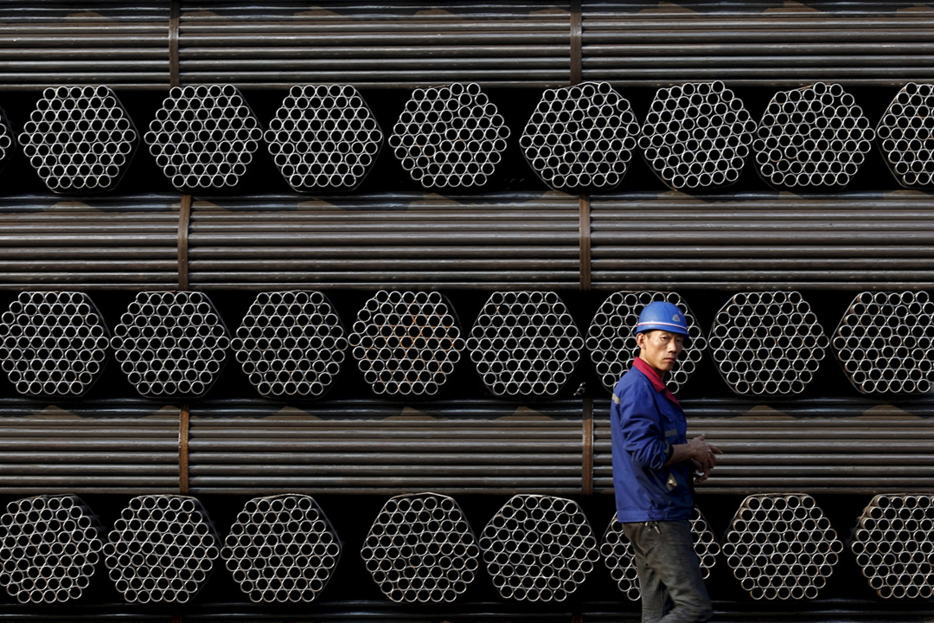<p>A worker stands in front of steel piping at a plant in China’s Hebei Province.</p>