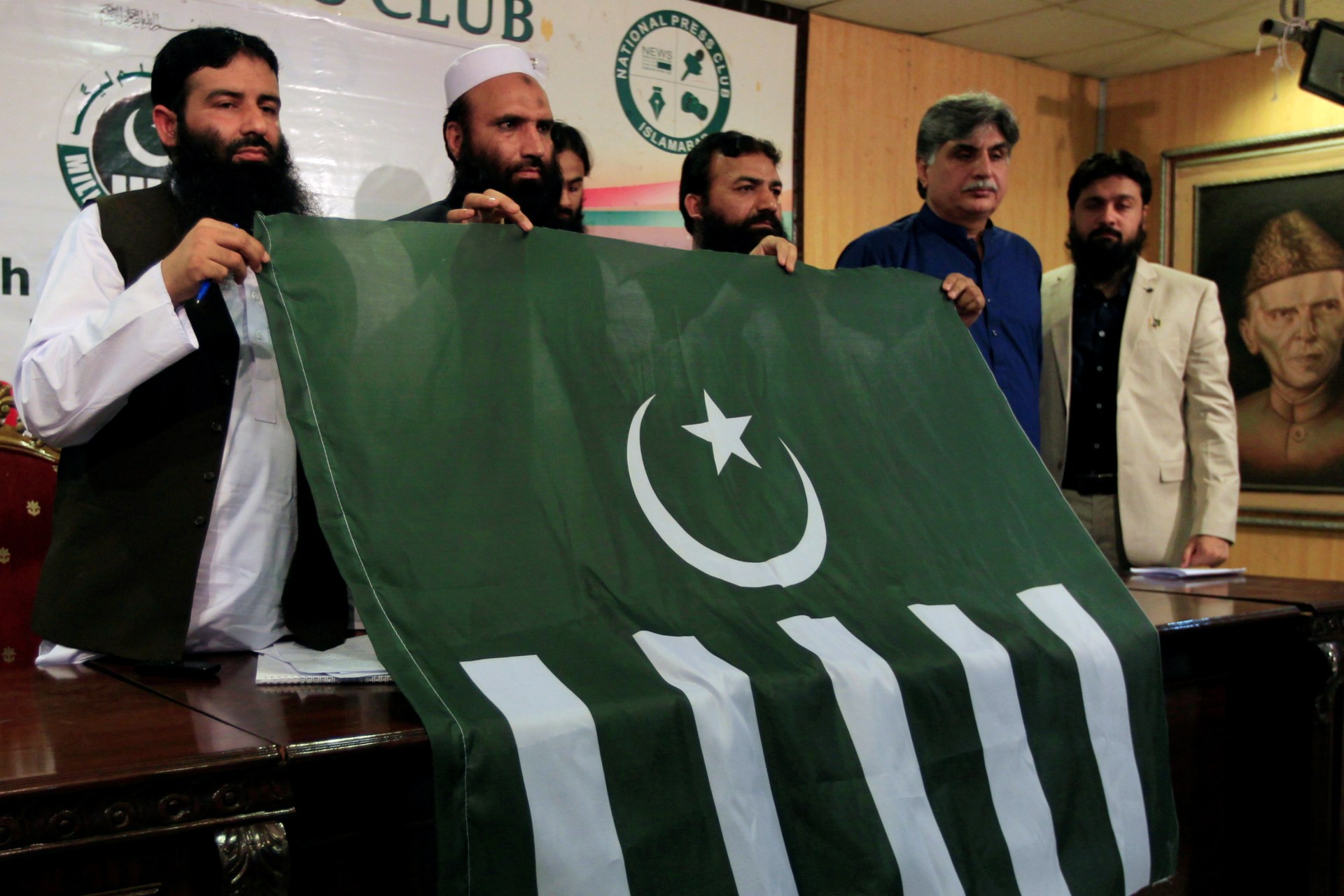 <p>Saifullah Khalid (2nd L), president of the Milli Muslim League political party, holds a party flag with others during a news conference in Islamabad, Pakistan, August 7, 2017. </p>