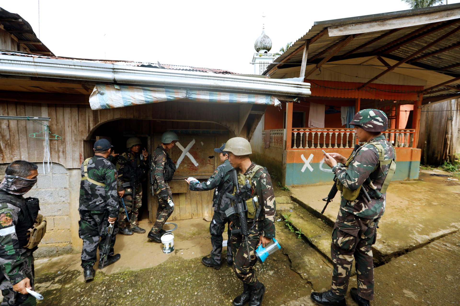 <p>Members of the Philippine National Police (PNP) mark a house after clearing it as government troops continue their assault against insurgents from the Maute group in Marawi city on June 29, 2017.</p>
