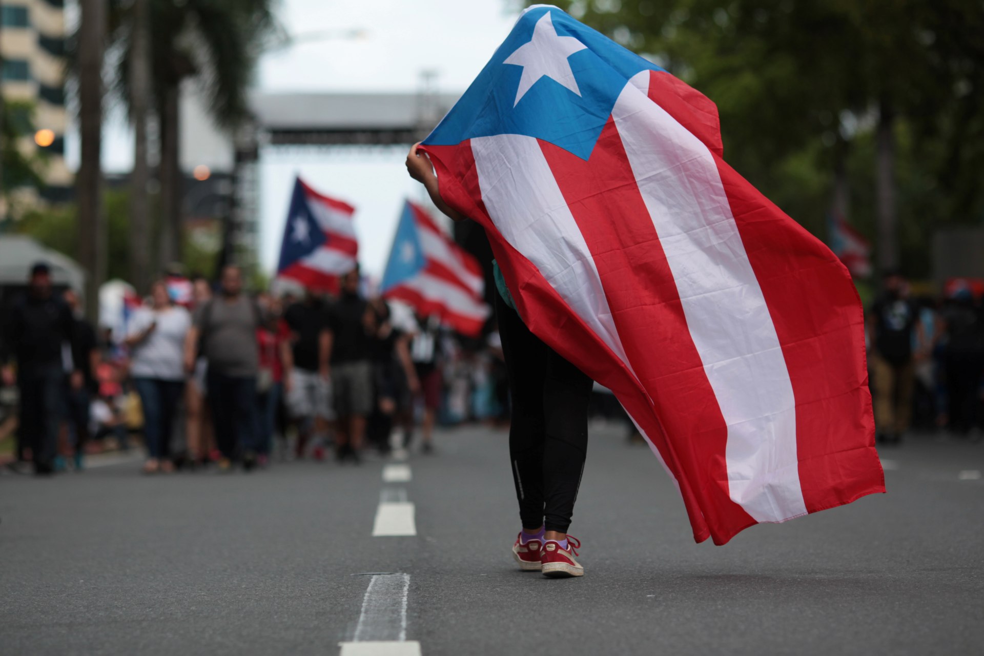 <p>A protester carries a Puerto Rican flag during a rally opposing the government’s austerity measures.</p>
