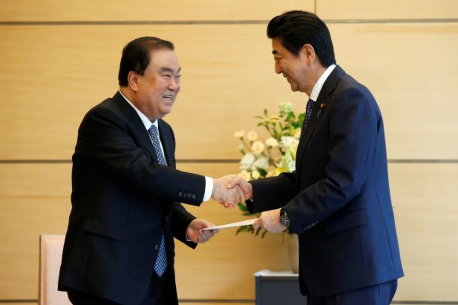 <p>South Korean special presidential envoy Moon Hee-sang (L) shakes hands with Japan’s Prime Minister Shinzo Abe as he hands a letter from South Korea’s President Moon Jae-in to Abe at Abe’s official residence in Tokyo, Japan, May 18, 2017(Reuters/Toru Hana)</p>