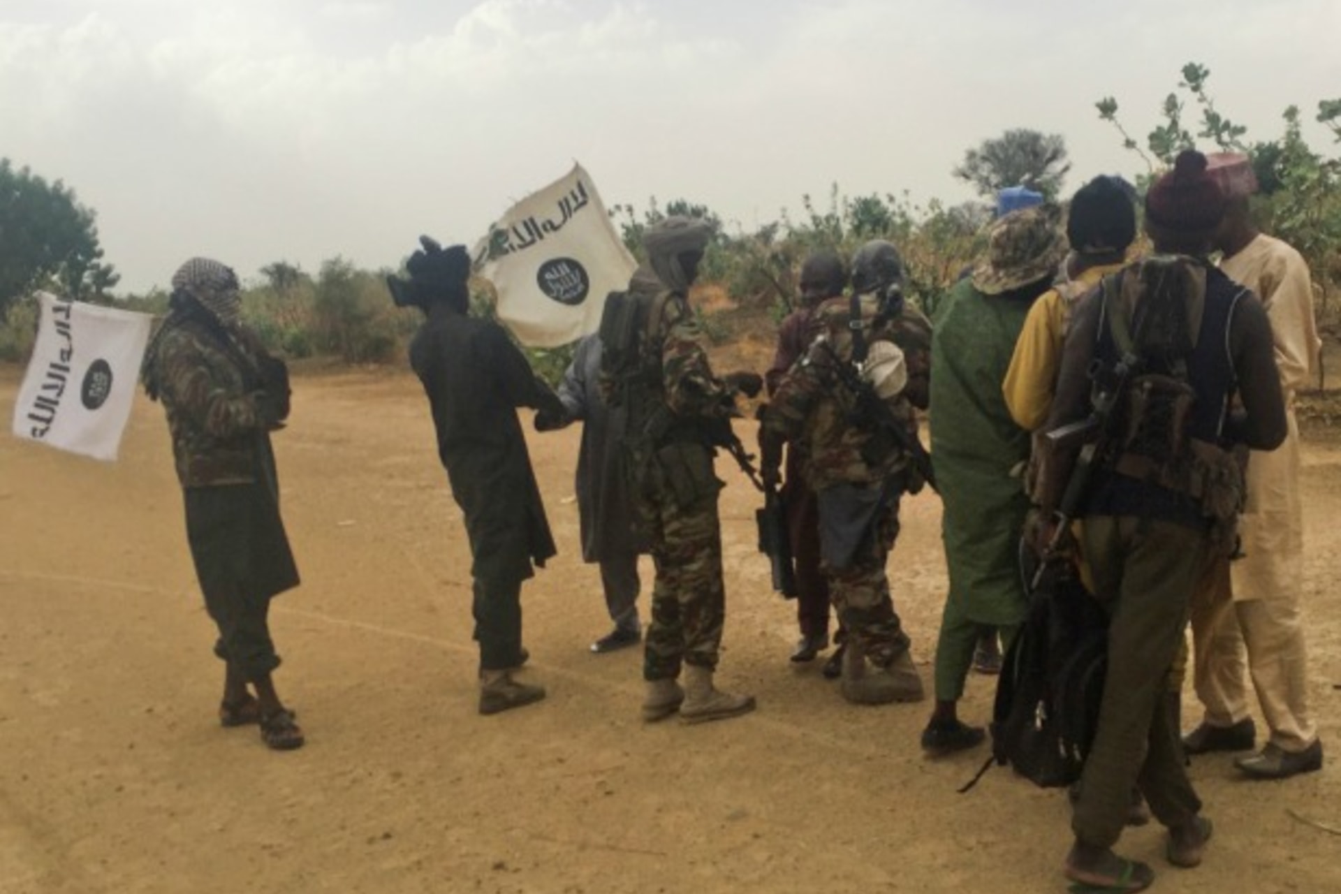<p>Boko Haram militants (in camouflage) embrace and shake hands with Boko Haram prisoners, released in exchange for a group of 82 Chibok girls, who were held captive for three years by Islamist militants, near Kumshe, Nigeria, May 6, 2017.</p>
