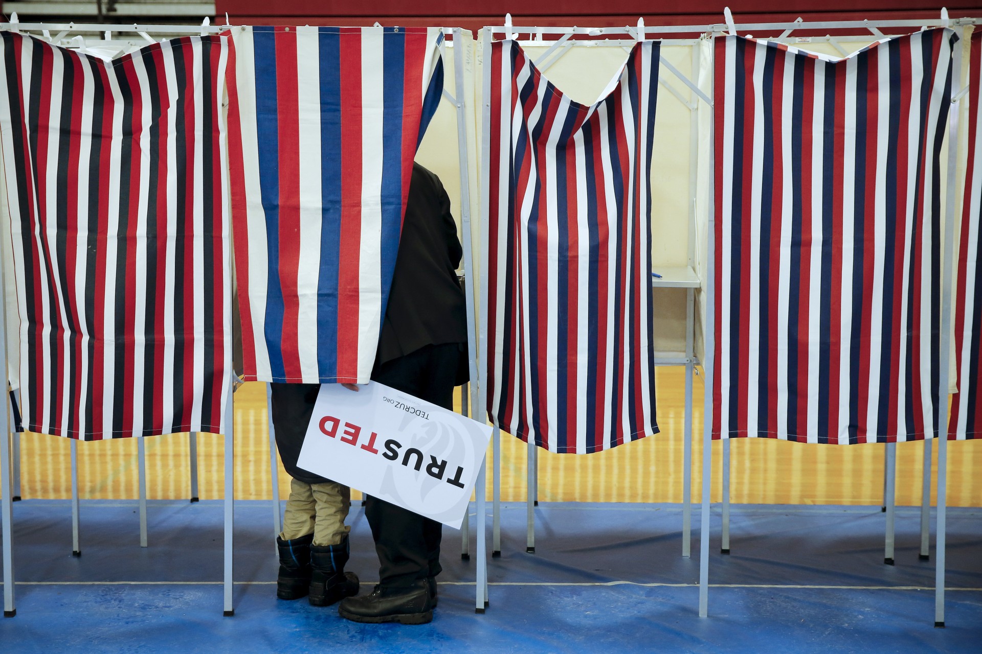 <p>A person holding a Ted Cruz sign stands in a voting booth with a child in Bedford, New Hampshire, February 9, 2016.</p>
