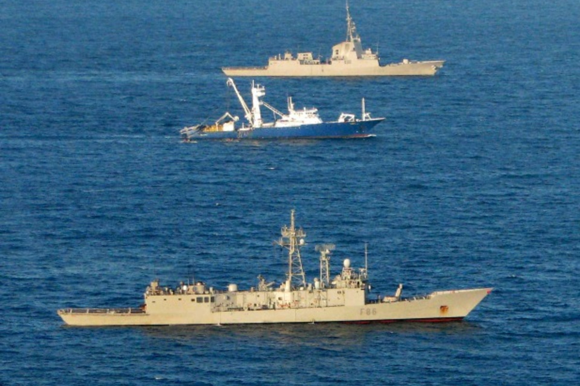 <p>The Spanish tuna fishing boat Alakrana sails between two accompanying Spanish warships in the Indian ocean after it was freed from Somali pirates November 17, 2009. </p>
